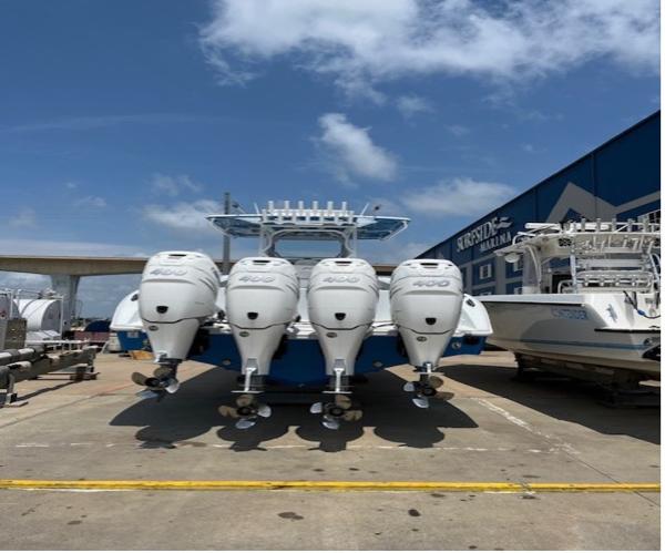 2022 Yellowfin 39 Offshore boat with four powerful outboard engines, docked under a clear sky.