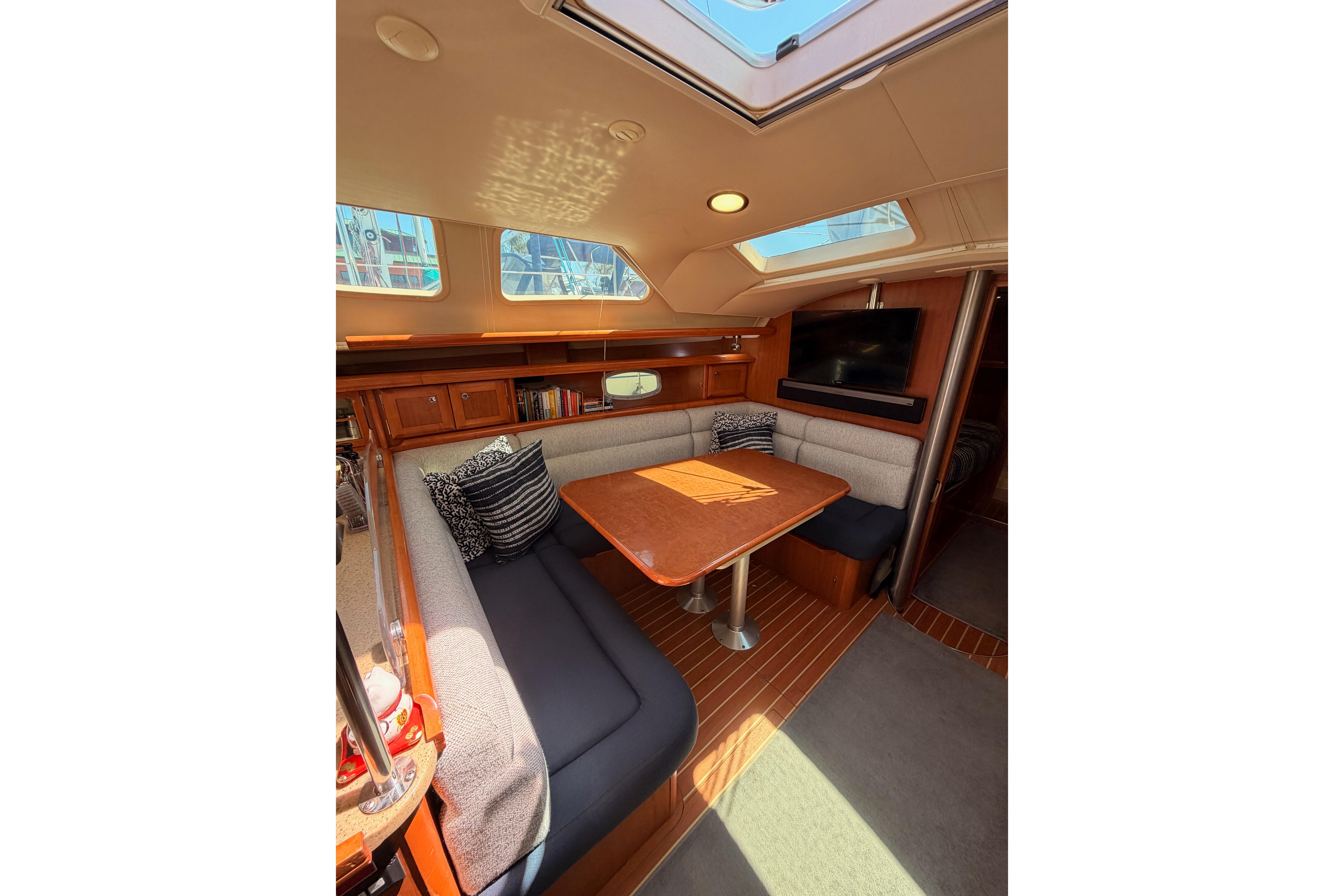 Interior of 2008 Hunter 45 Deck Salon with cozy seating and wooden table.