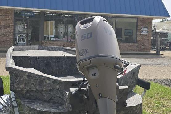 2026 Havoc 1553 VJST boat with outboard motor in front of a store.