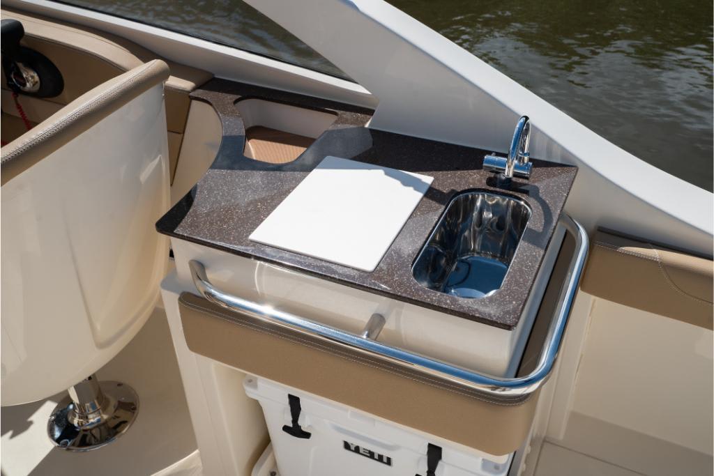 2023 Scout 240 Dorado boat interior with sink and cutting board.