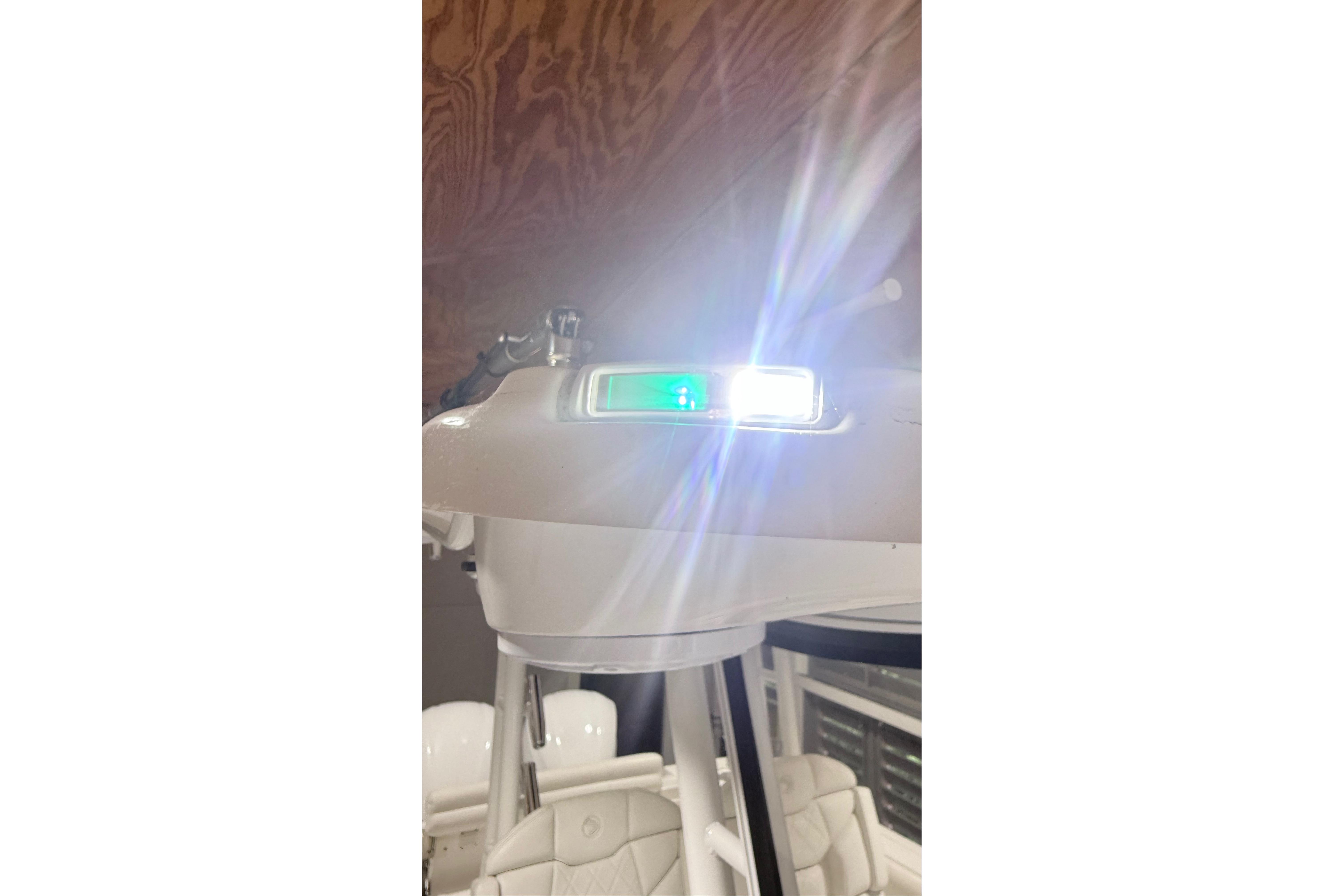 2022 Edgewater 280CC boat with illuminated navigation light in a wooden interior setting.