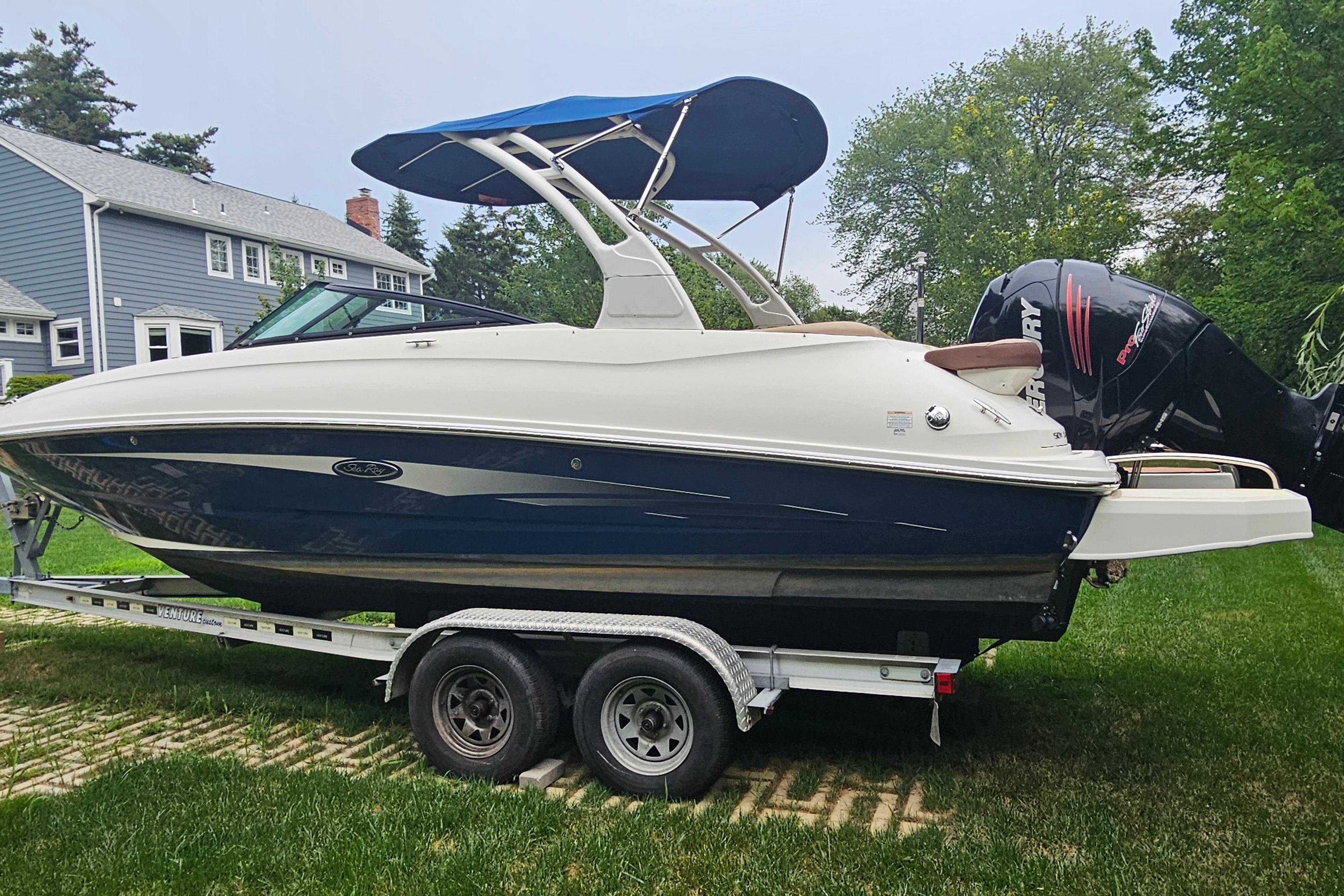 2017 Sea Ray SDX 240 Outboard boat on trailer, parked on grass.