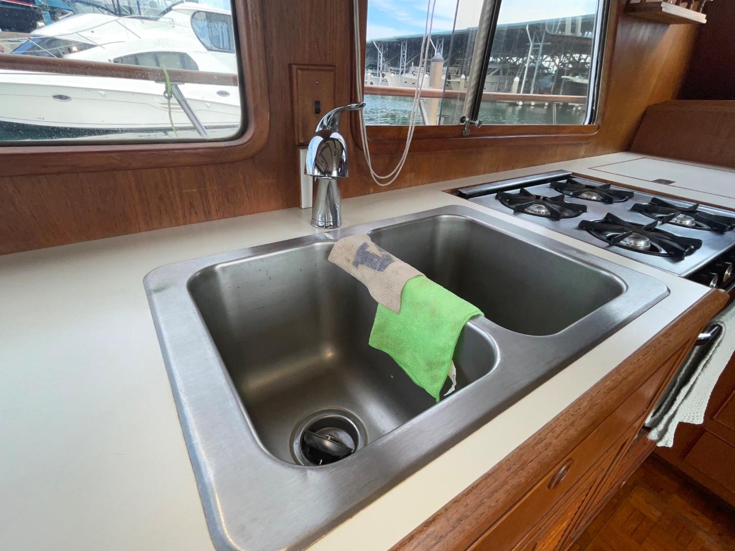 1983 Ocean Alexander TRI Cabin kitchen sink and stove with marina view.