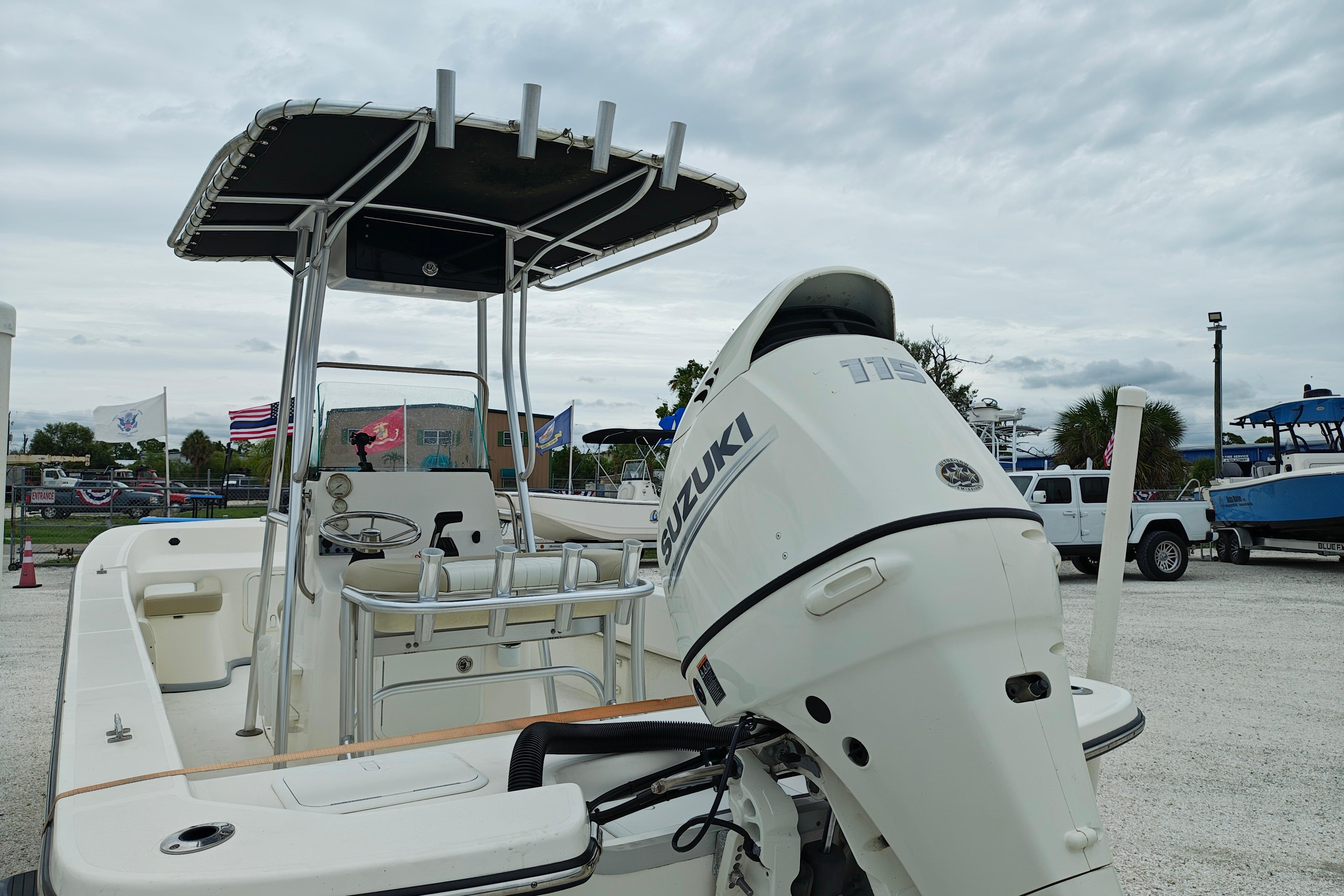 2018 Sundance B20CCR boat with Suzuki outboard motor, parked outdoors under cloudy sky.