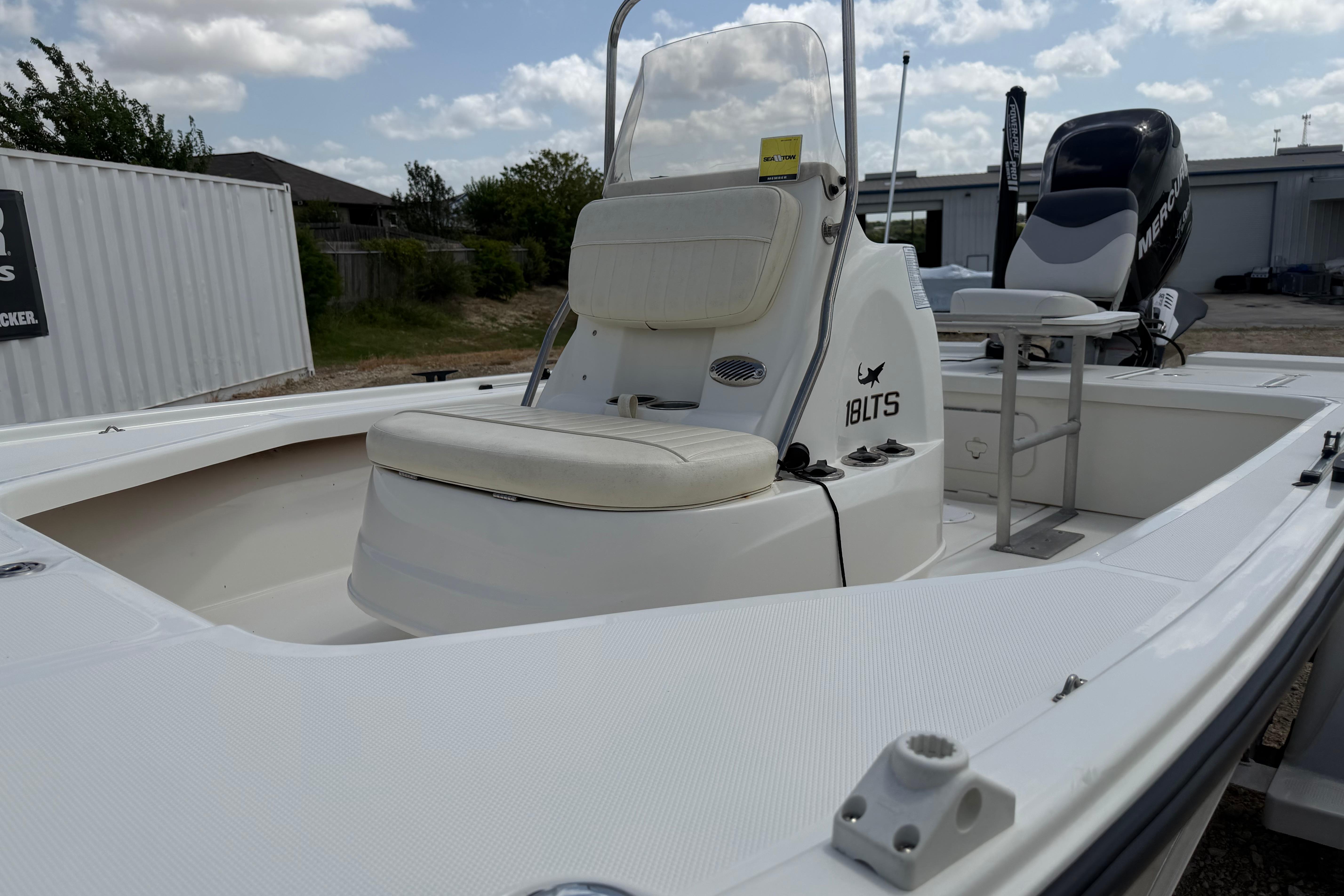 2012 Mako 18 LTS boat with seating and console, parked outdoors under cloudy sky.