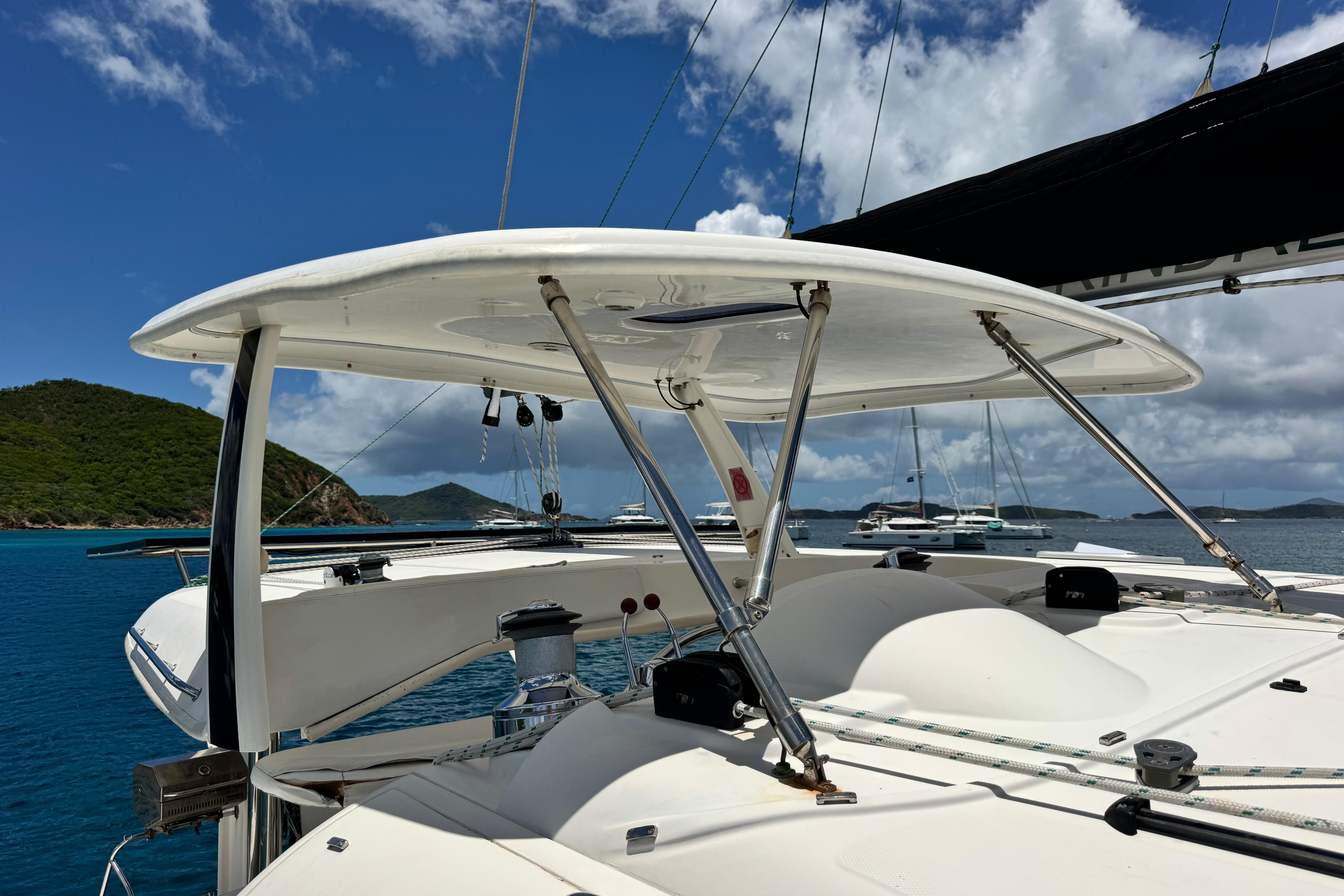 Sailing yacht Leopard 46, 2011 model, anchored in a scenic bay with clear skies.