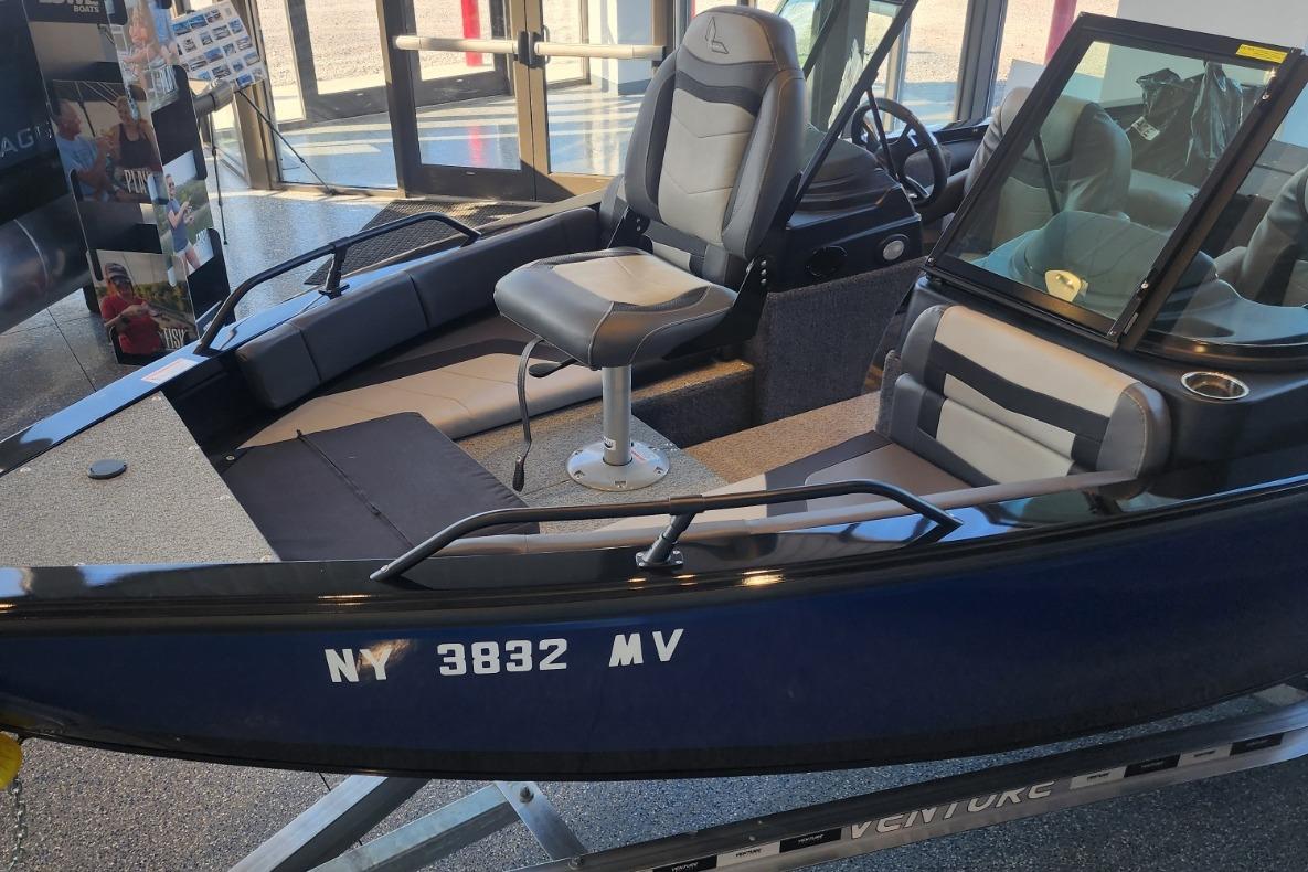 2023 Lowe boat interior with seating and windshield, displayed indoors.