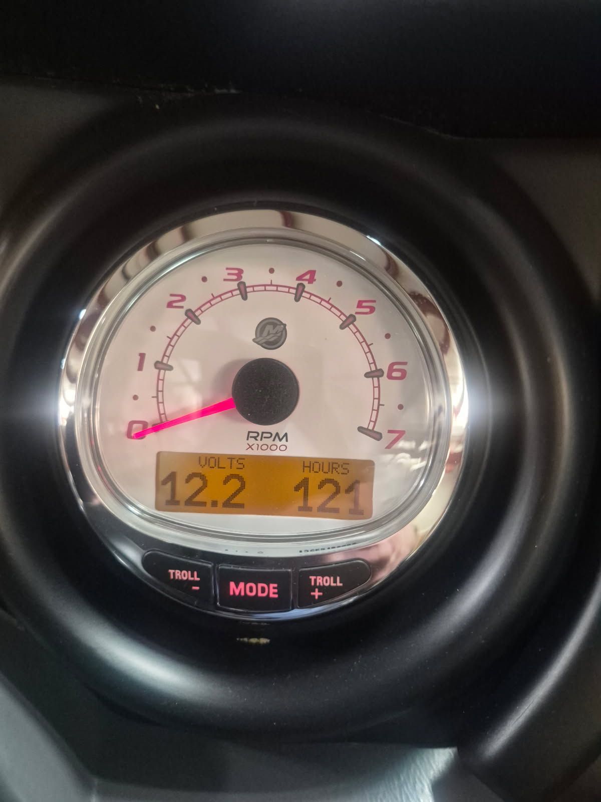 Close-up of a boat tachometer with digital displays for volts and engine hours.