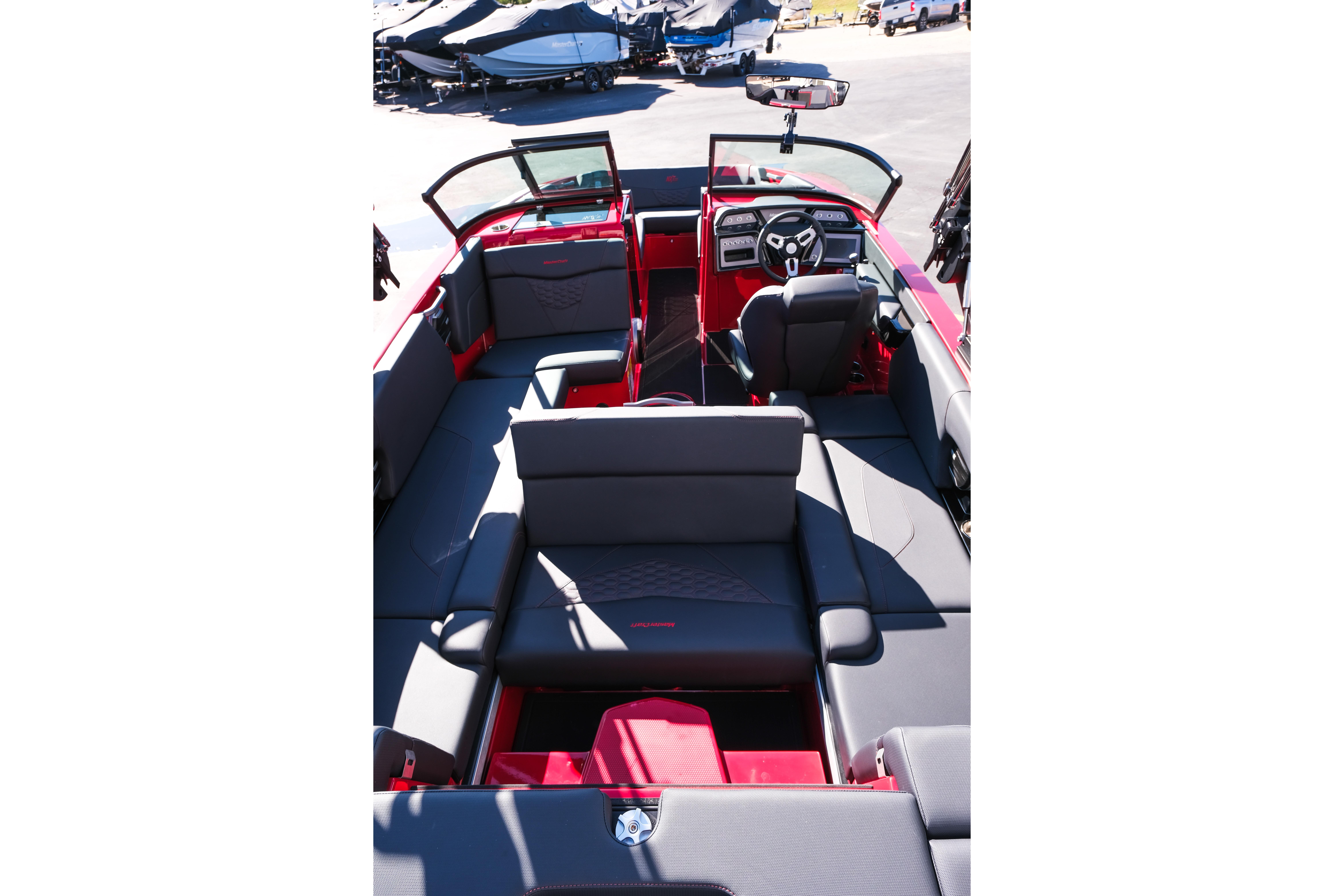2026 MasterCraft NXT22 boat interior with red and gray seating, modern dashboard, and open layout.
