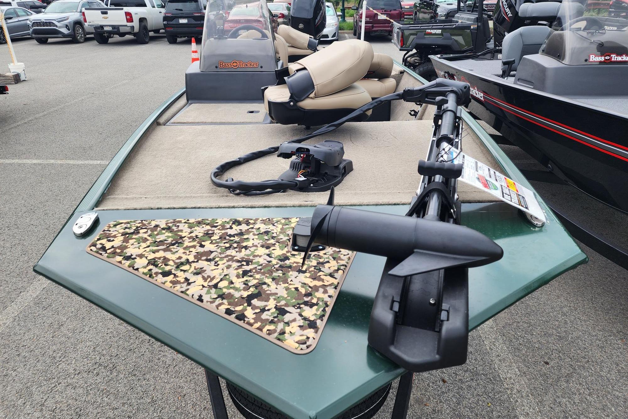 2026 Tracker Bass Tracker Classic Limited boat with camouflage deck, parked in a lot.