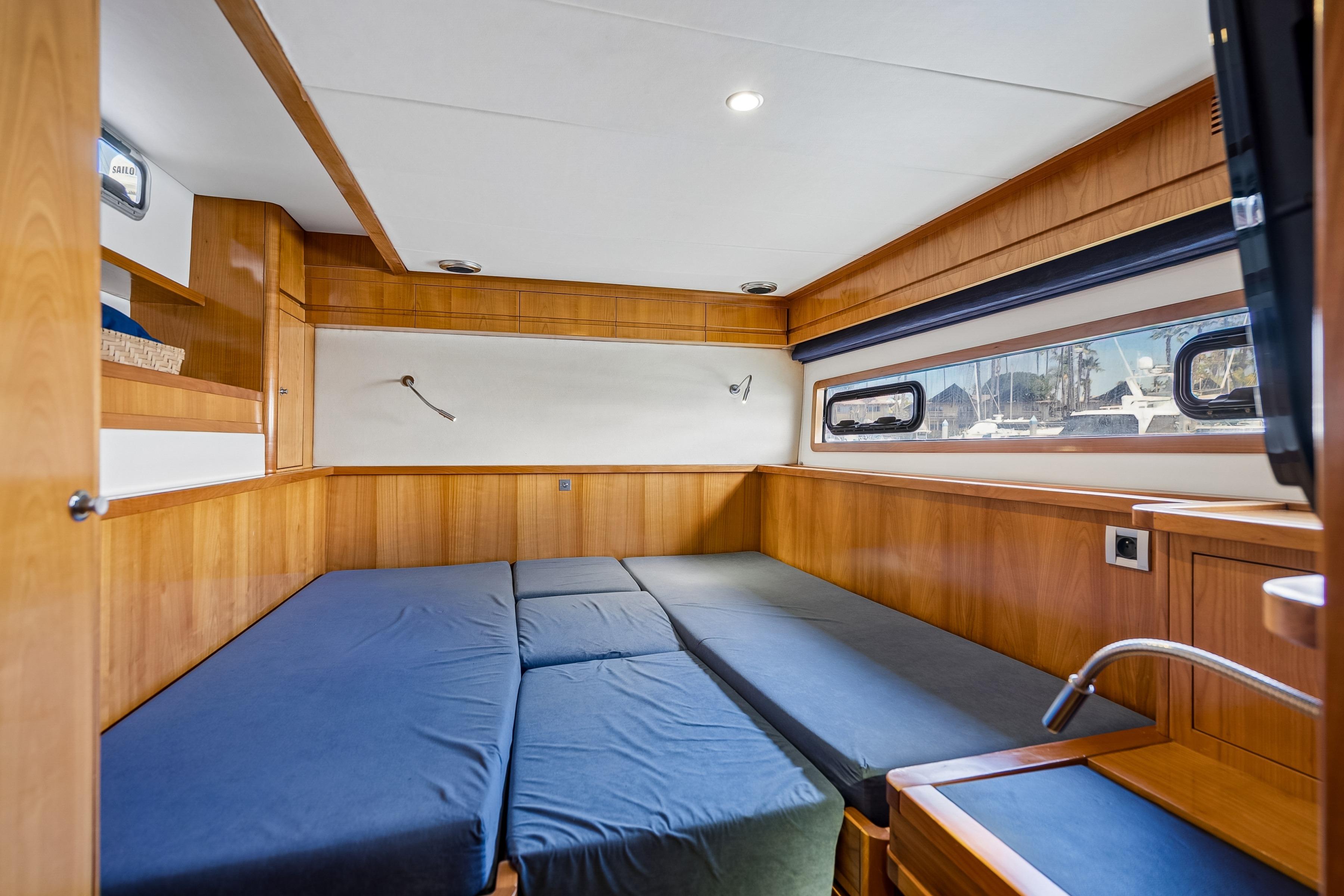 Luxurious 2009 Catana 65 yacht cabin with wooden interior and comfortable bedding.