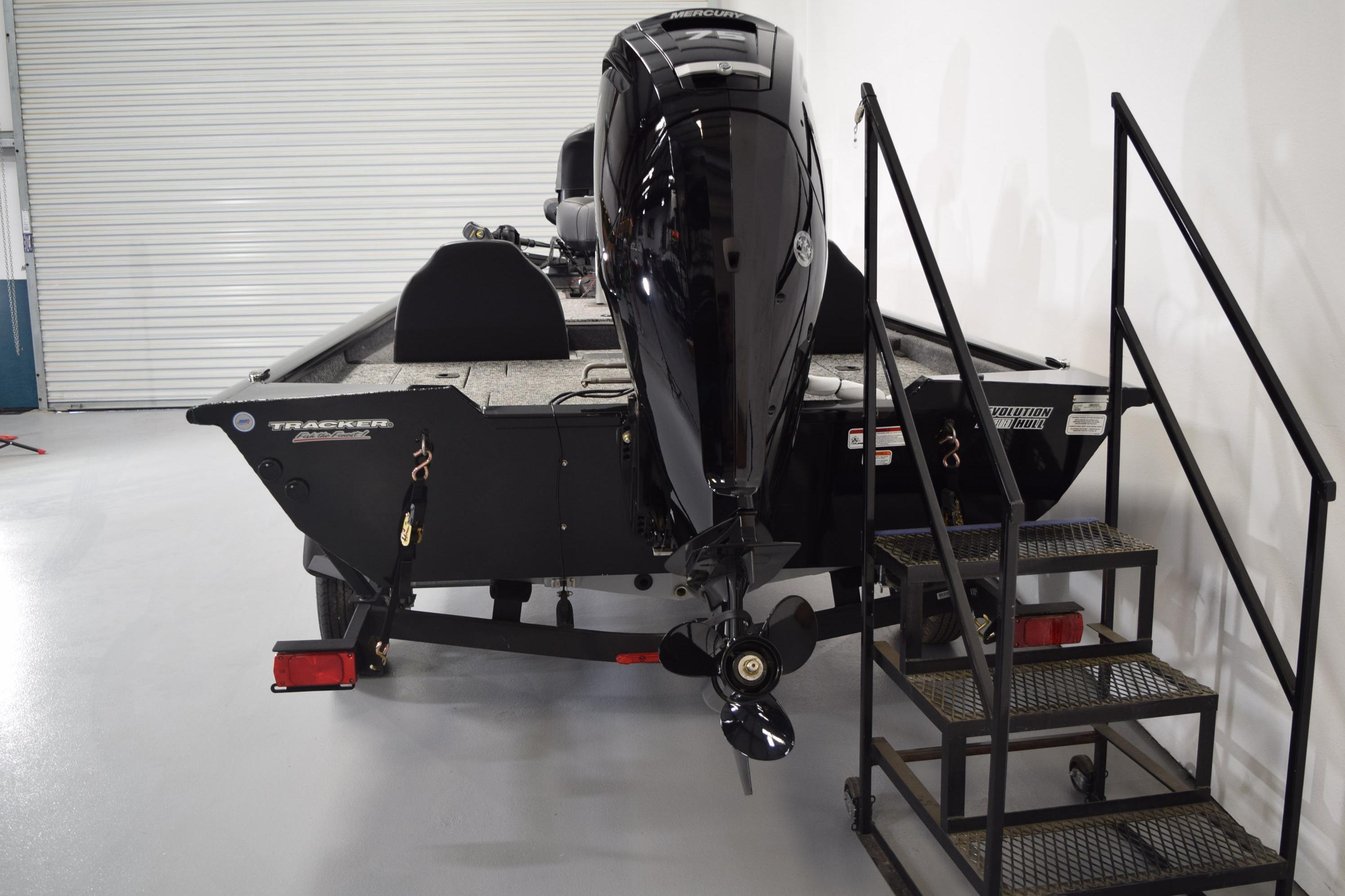 2026 Tracker Pro Team 175 boat with Mercury outboard motor in a showroom.
