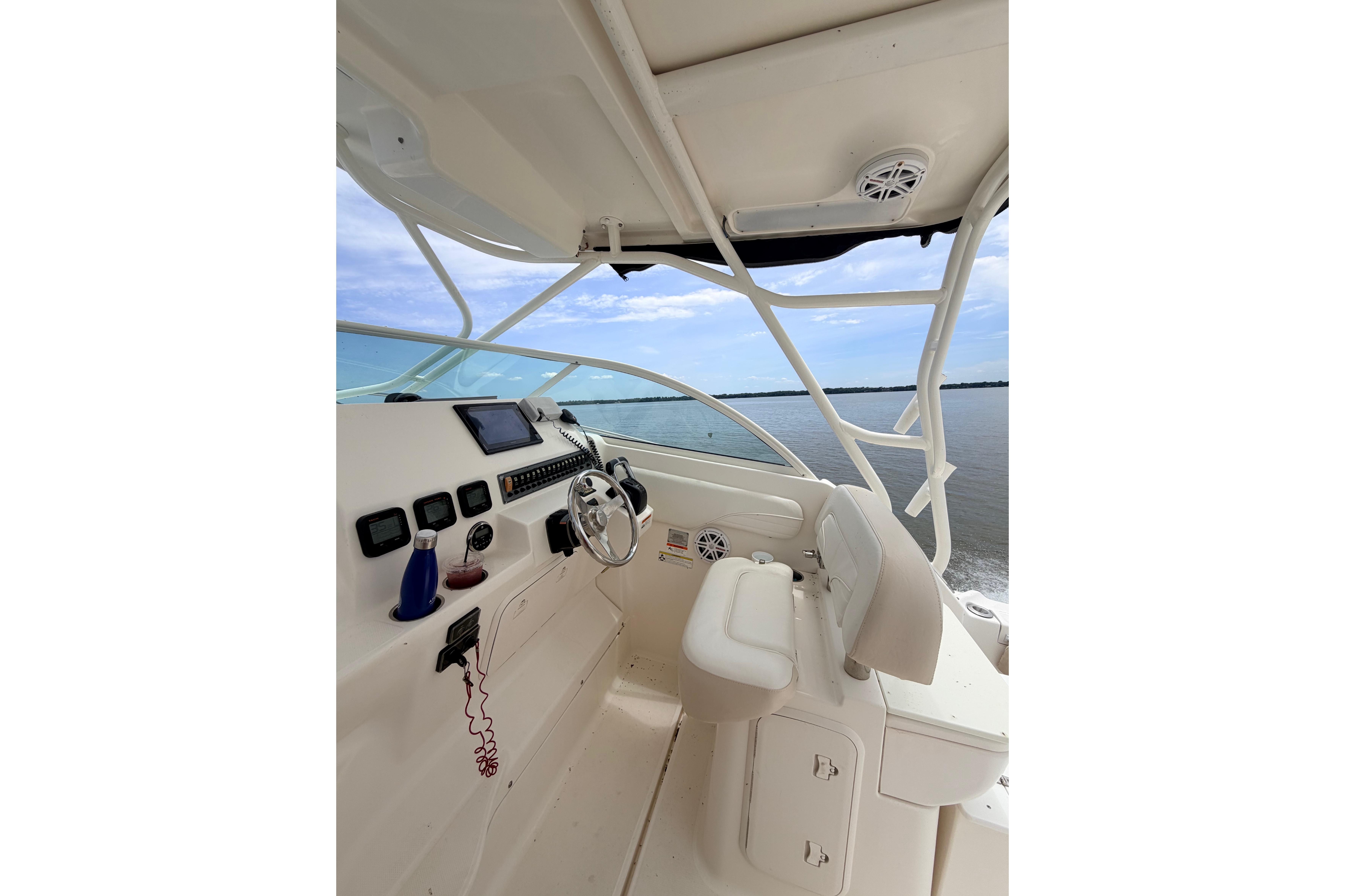 2015 Wellcraft 290 Coastal boat cockpit with steering wheel and navigation equipment.