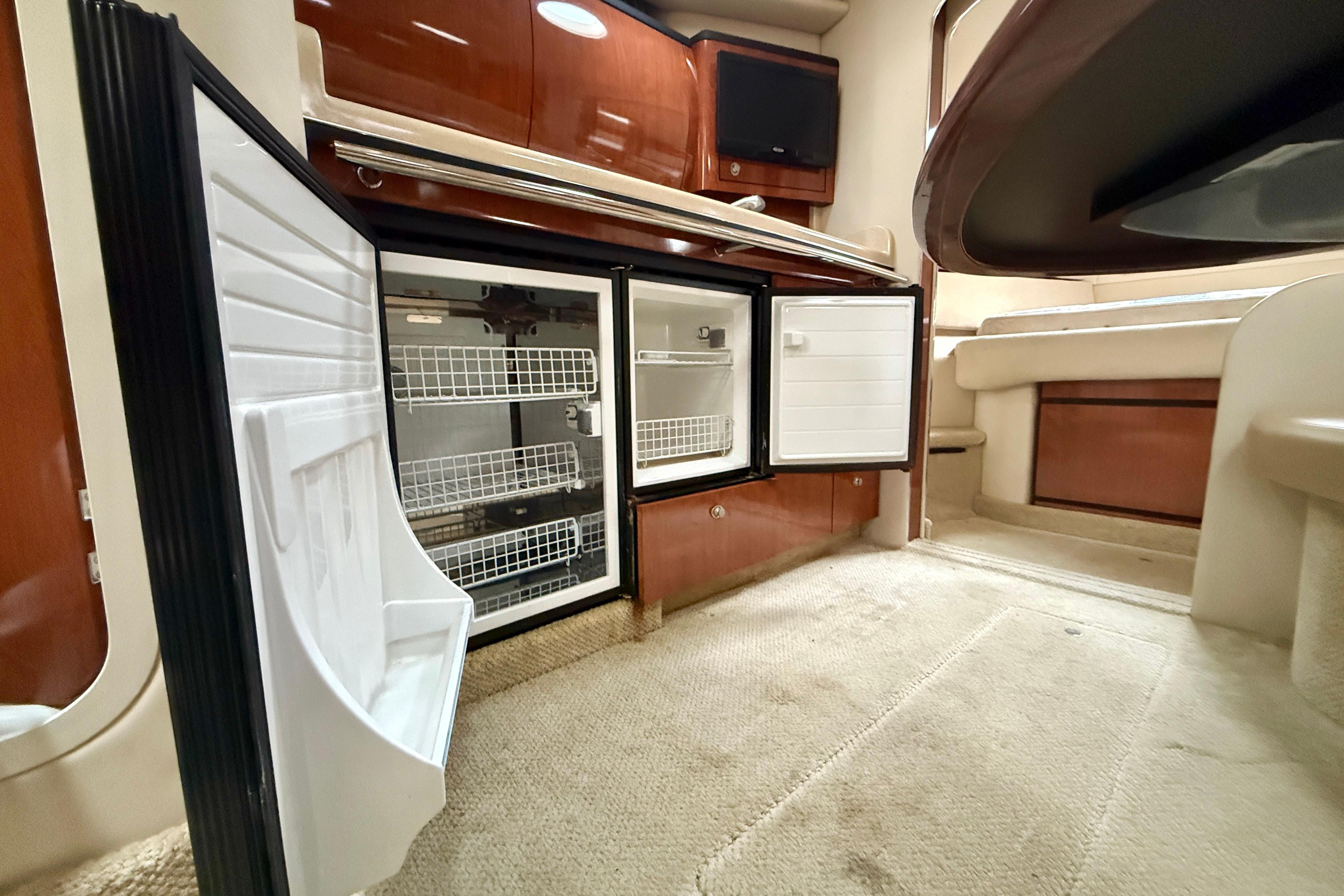 2004 Searay 360 Sundancer interior with open fridge, showcasing spacious cabin design.
