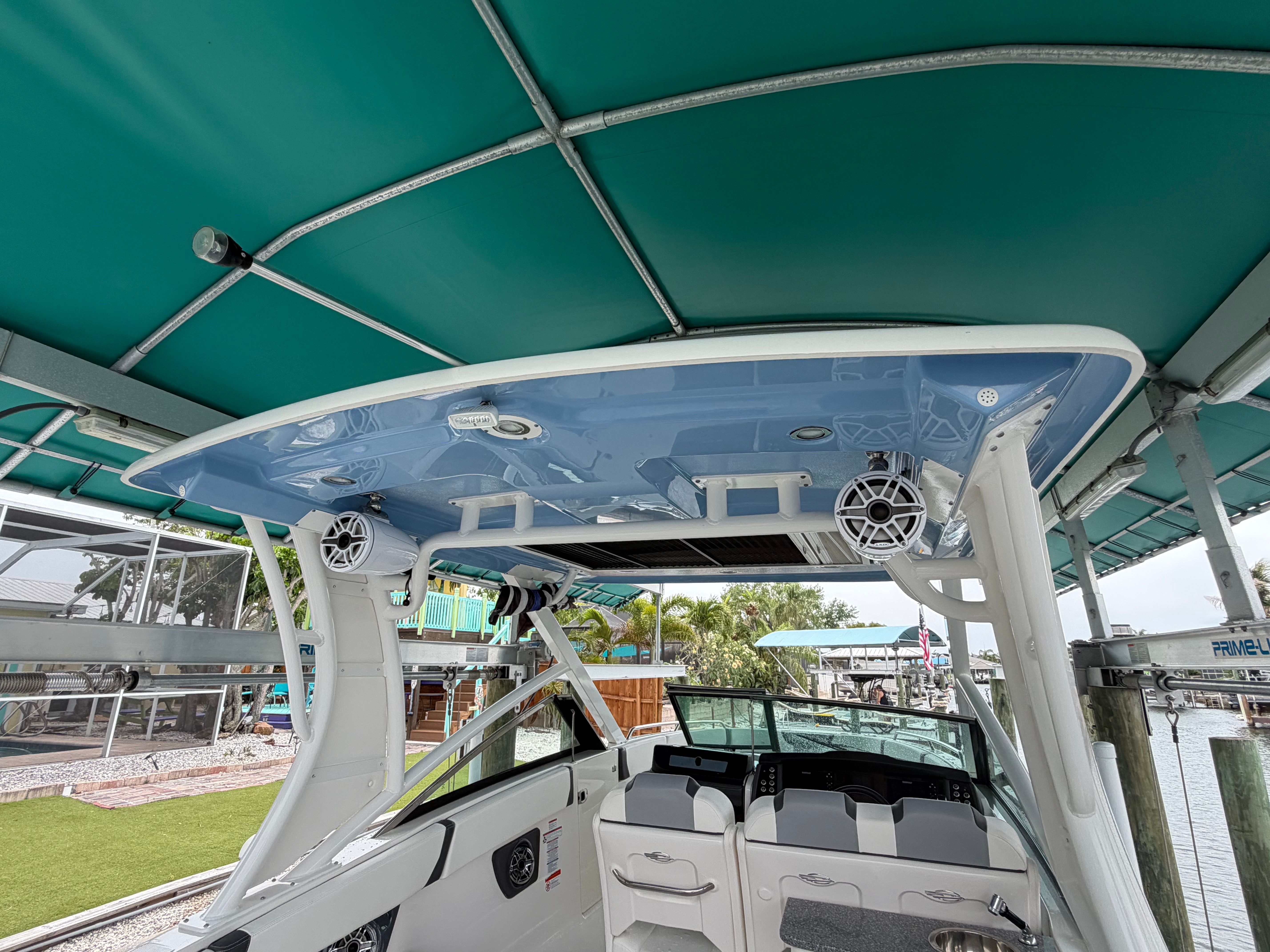 The boat features a modern design with a blue roof and white speakers.