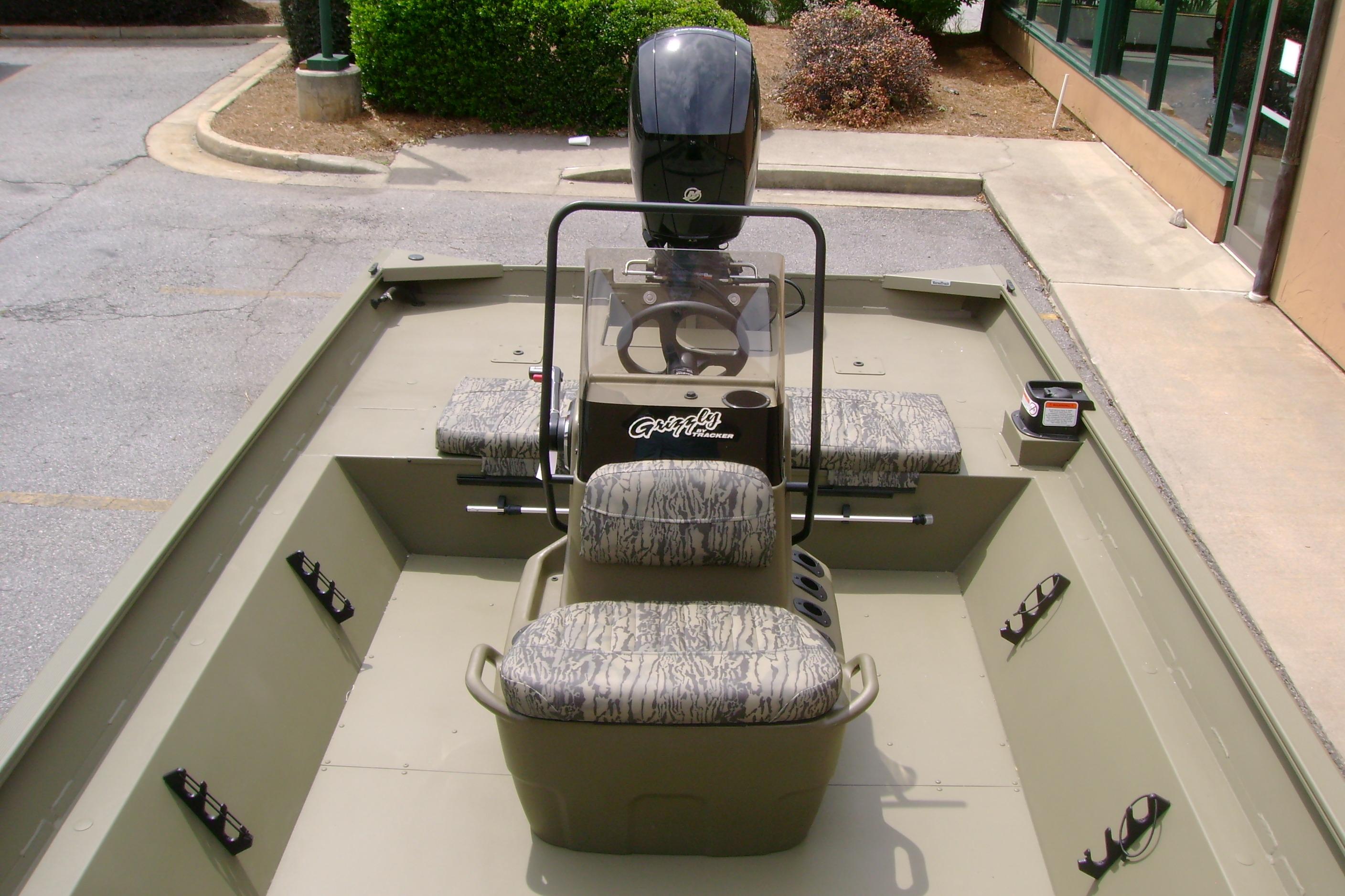 2026 Tracker Grizzly 2072 CC boat interior with camouflage seating and steering console.
