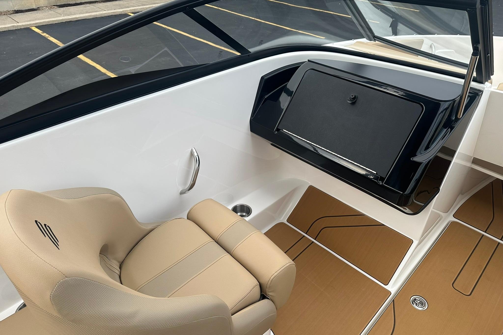 2026 Bayliner V20 boat interior with beige seating and sleek dashboard design.
