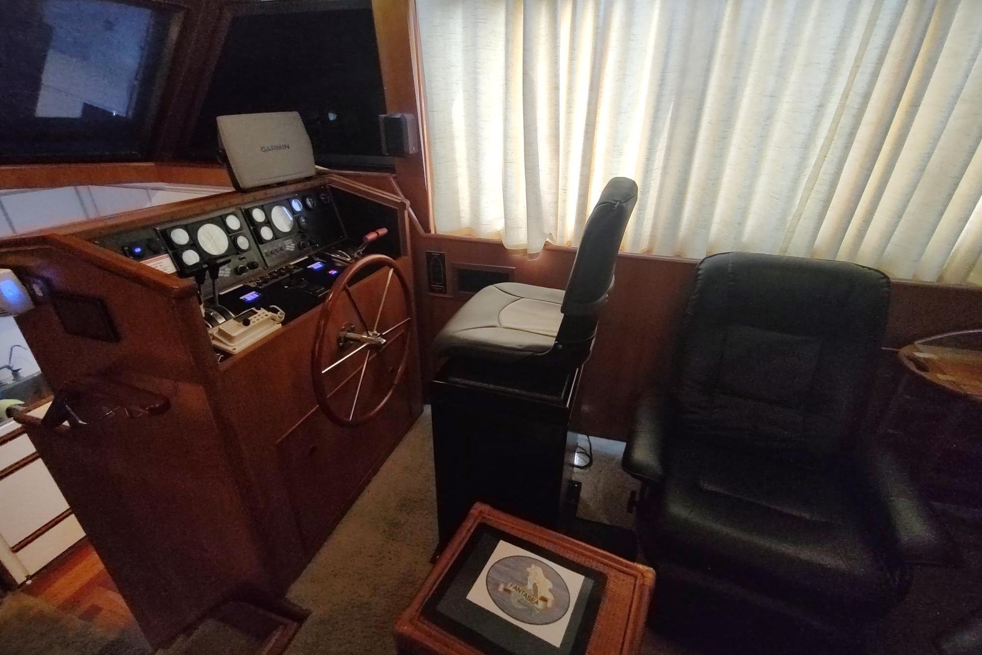 Interior helm of 1989 Hyatt Double Cabin Motoryacht with steering wheel and navigation equipment.