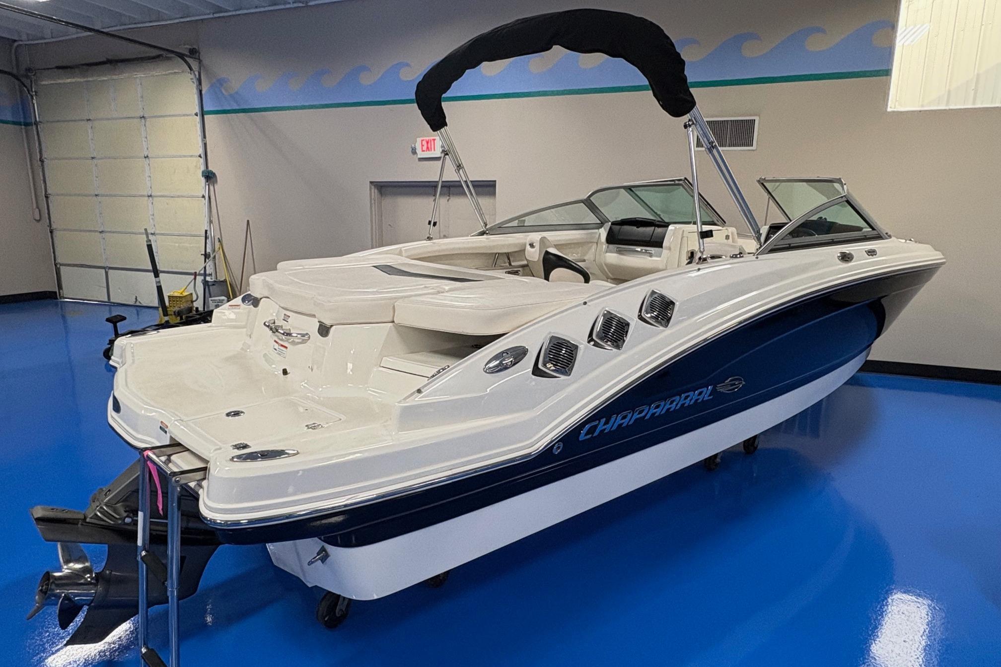 2011 Chaparral 216 SSi boat in showroom, featuring sleek design and blue accents.