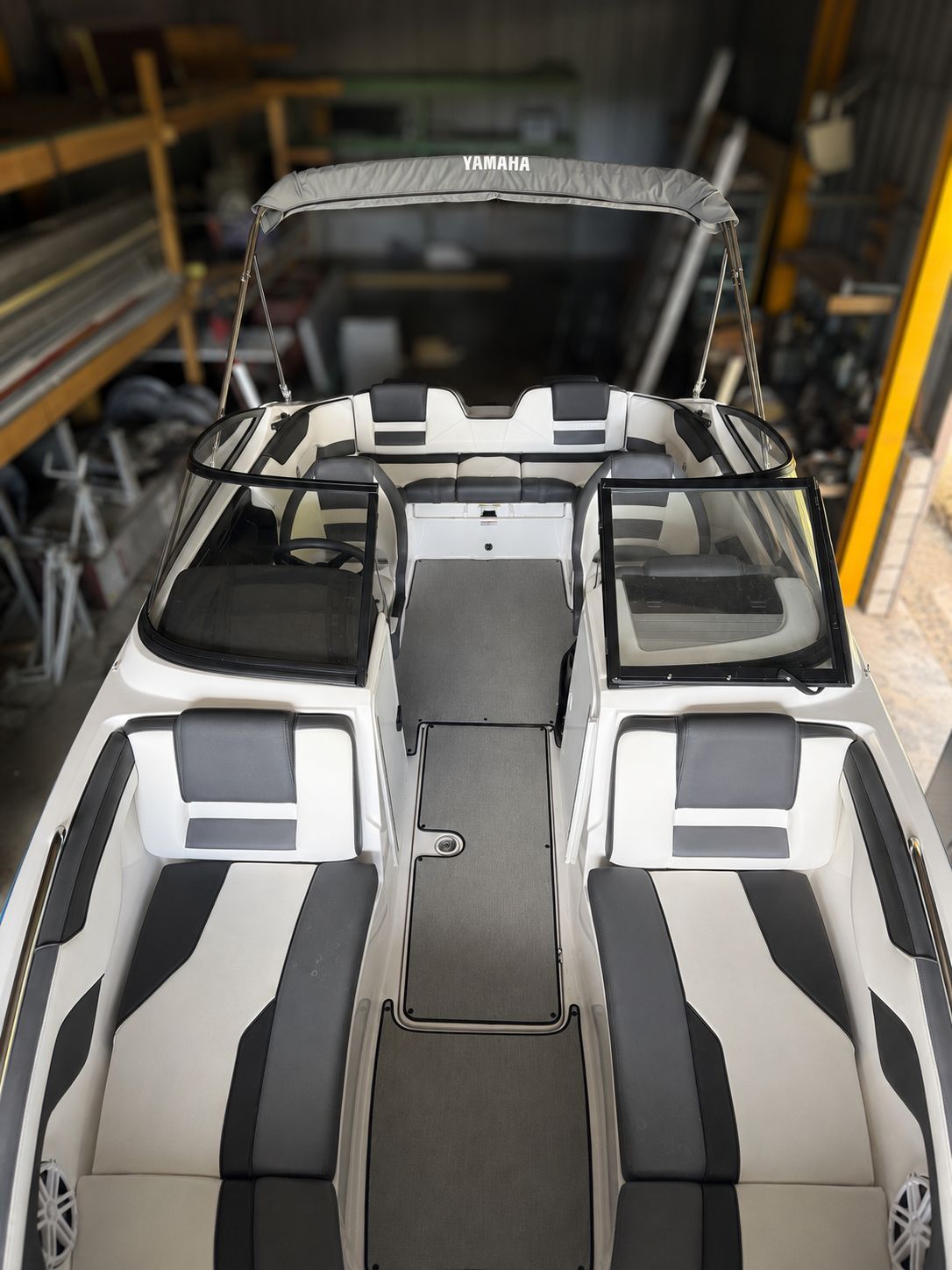 The image shows the cockpit of a 2021 Yamaha SX210 boat with gray and white seating.