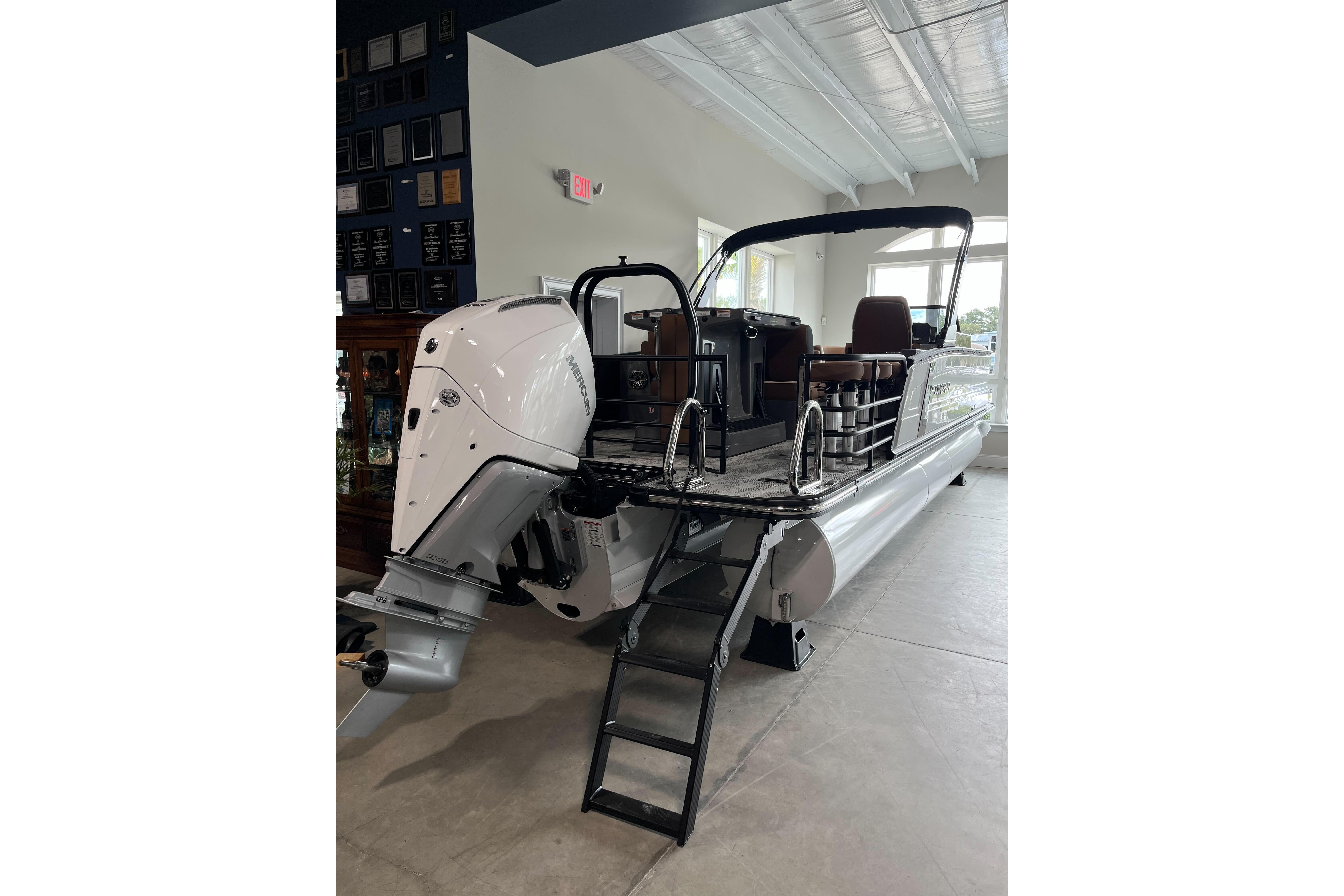 2026 Starcraft RX 25 DL DC pontoon boat with powerful outboard motor in showroom.