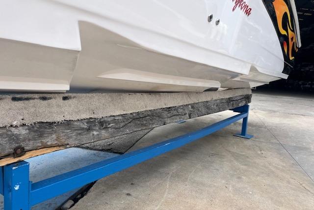 2000 Donzi 33 ZX boat on a blue trailer, showcasing hull design and vibrant graphics.
