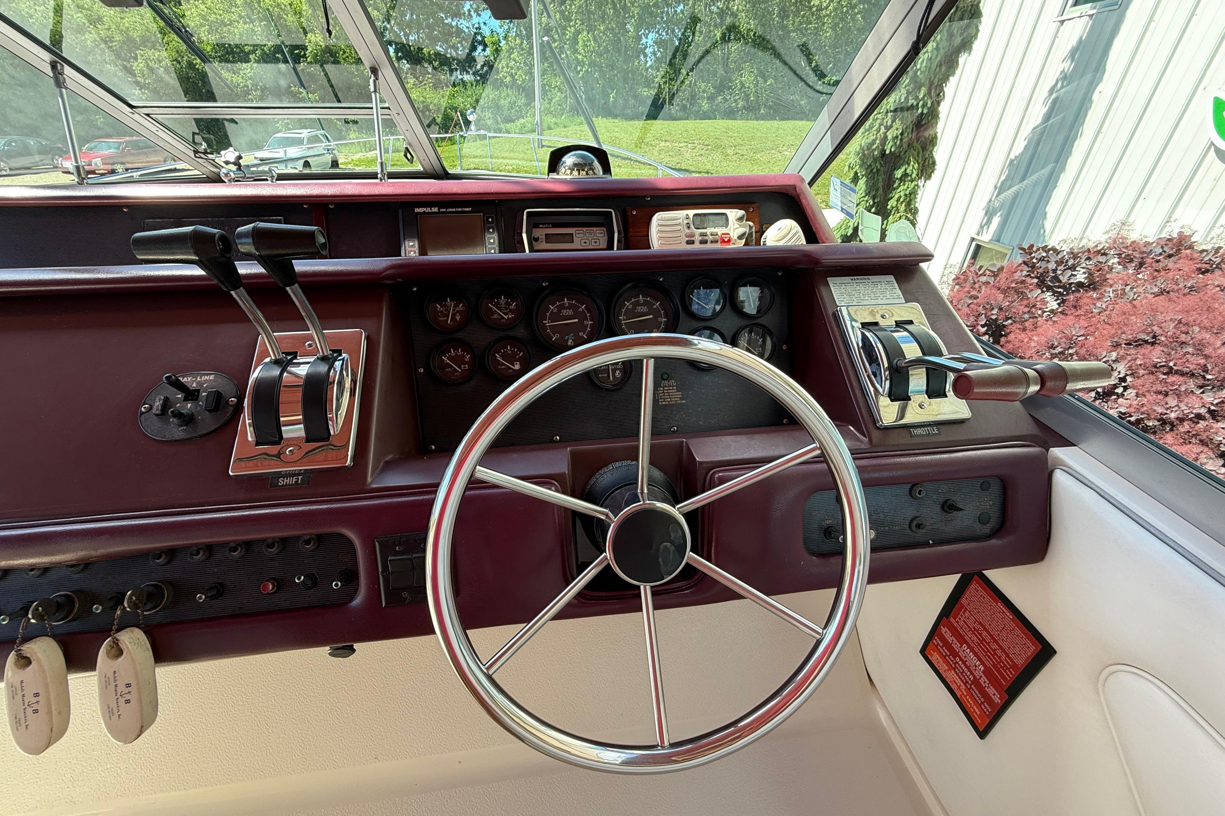 Cockpit of a 1990 Sea Ray 310 Express Cruiser with steering wheel and control panel.