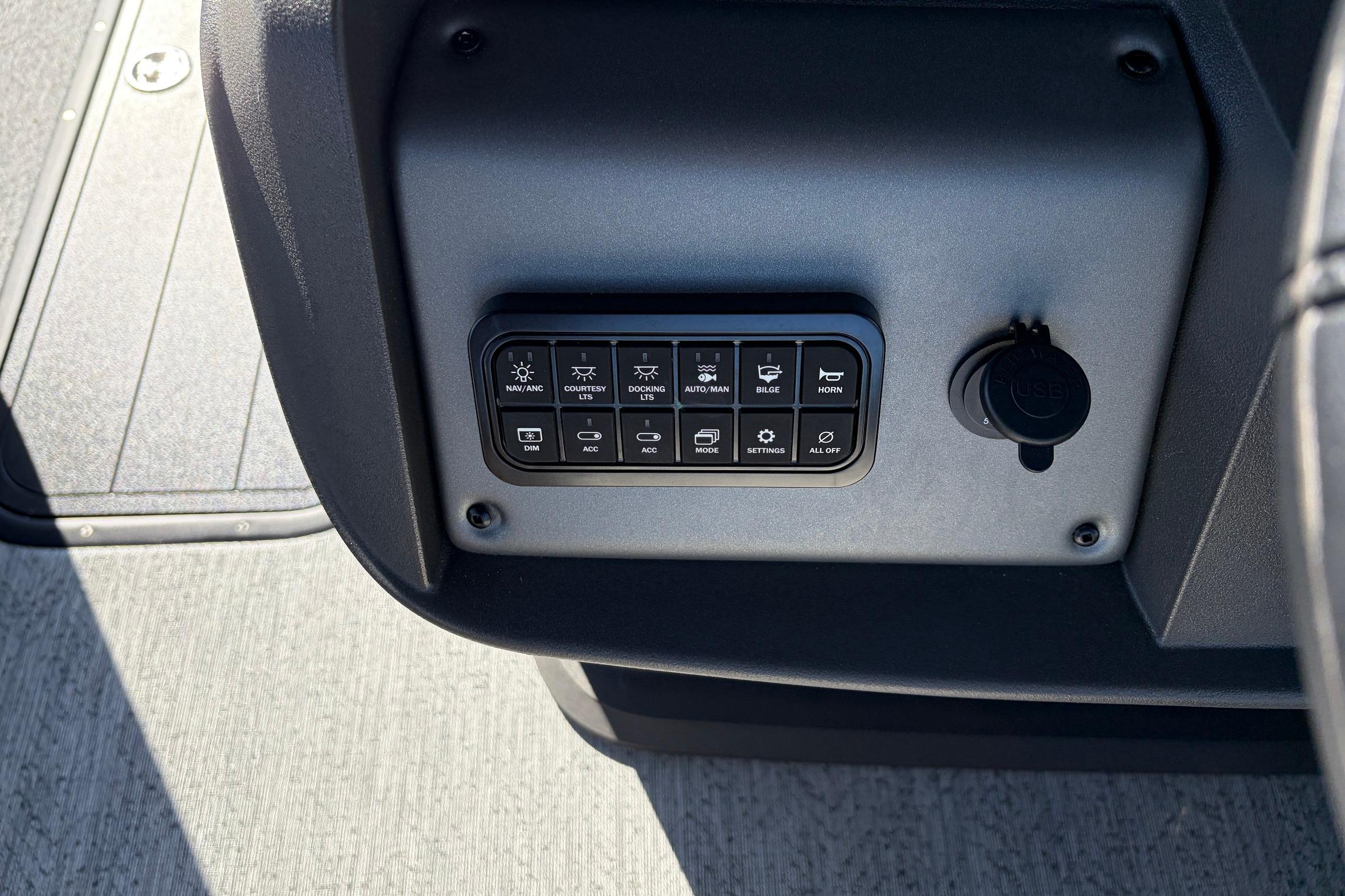 Control panel of 2026 Sun Tracker Fishin' Barge 22 XP3 with various switches and settings.