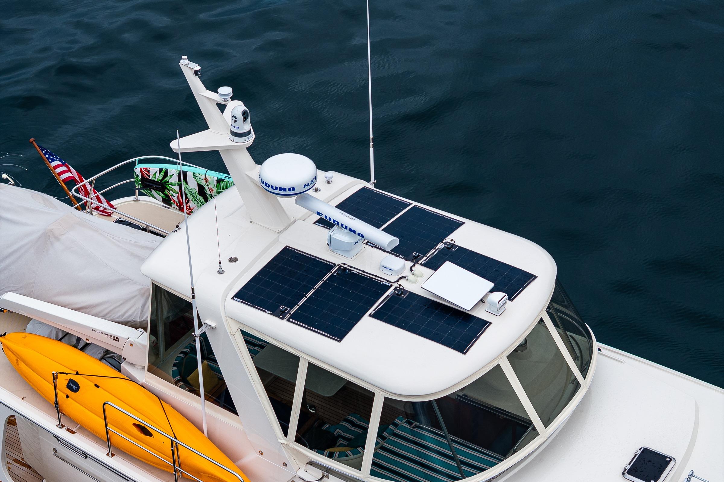 Fleming 55 Pilothouse 2026 with solar panels and kayak on deck, cruising on water.