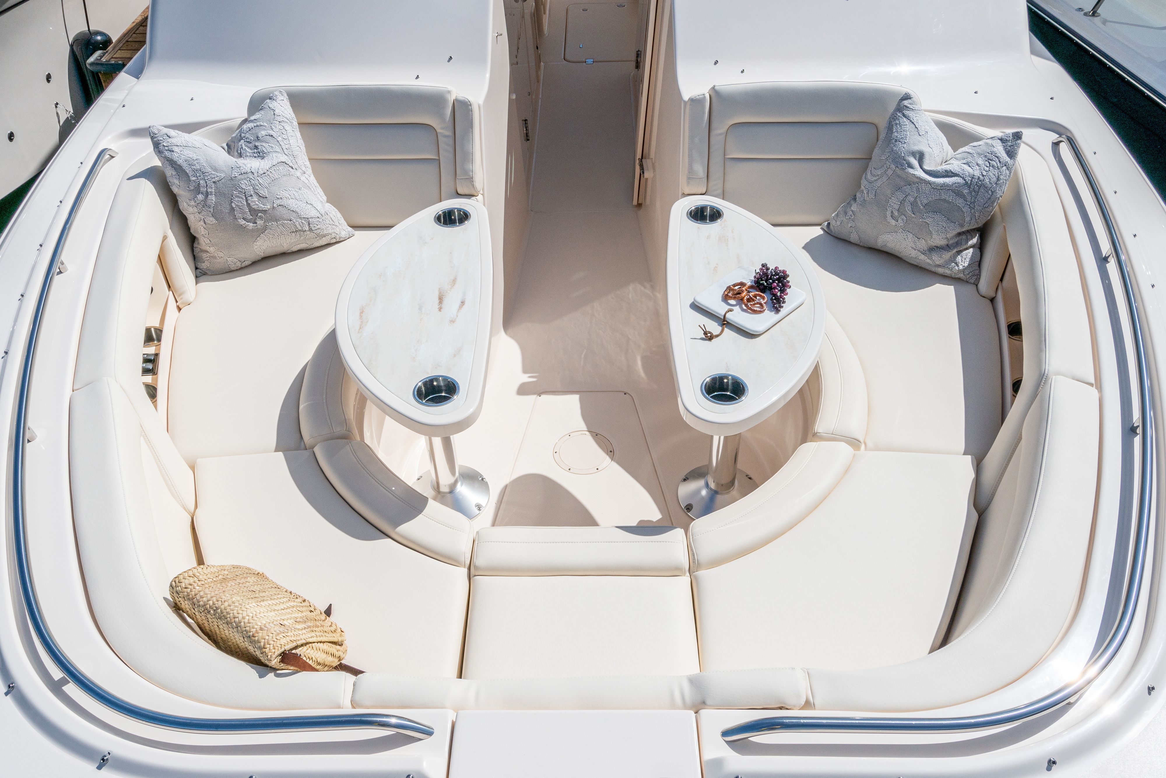 The image shows the seating area of a Grady-White Freedom 375 boat with elegant cushions and tables.