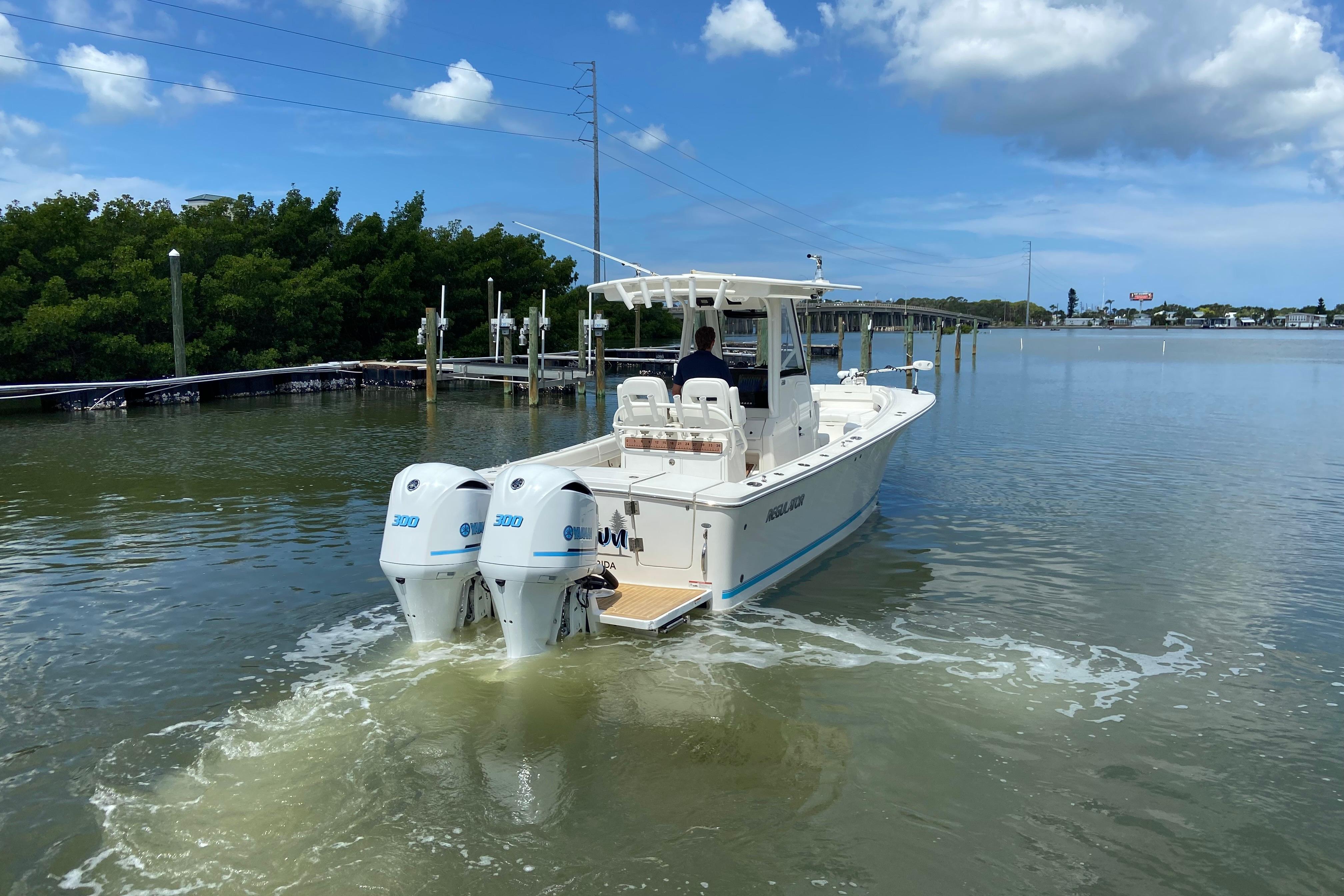 2021 Regulator 28 boat with twin Yamaha engines cruising in calm waters.