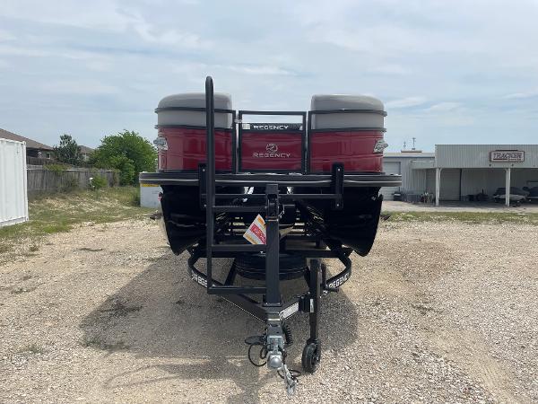 2023 Regency 250DL3 pontoon boat on trailer, rear view, parked outdoors.