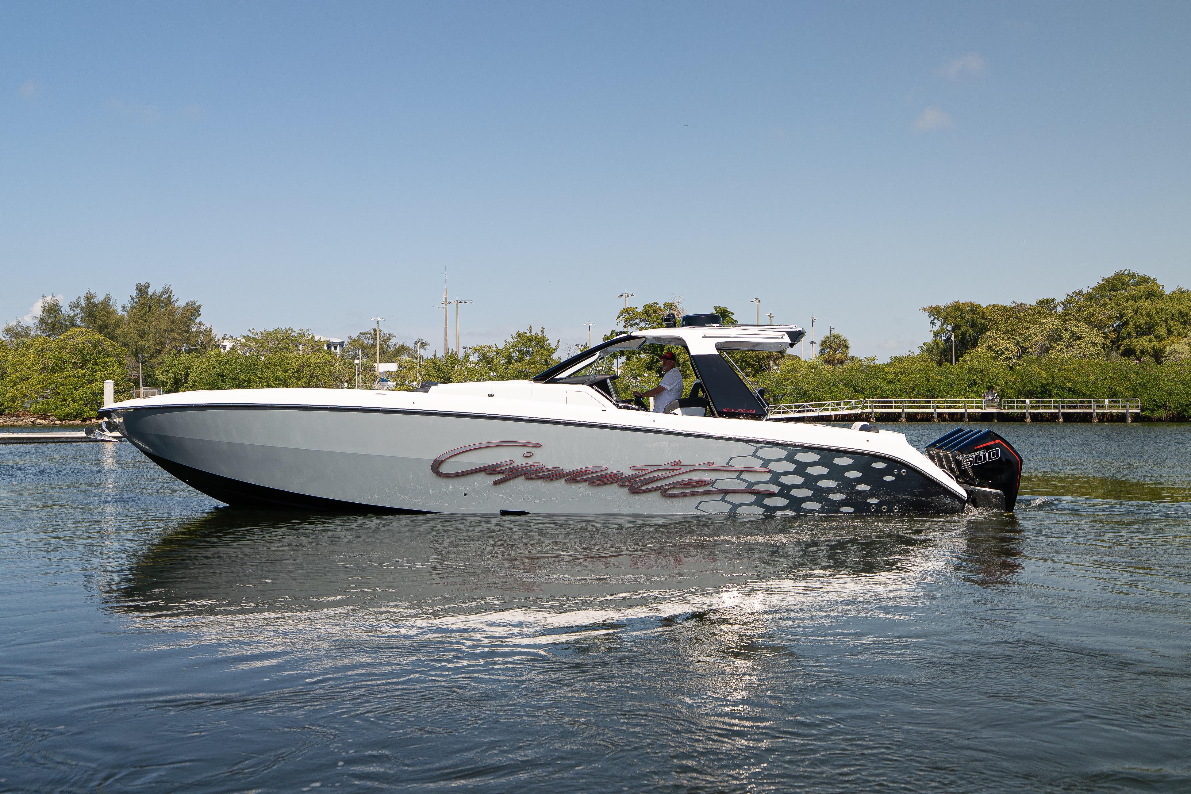 2025 Cigarette 42' Auroris boat cruising on a calm waterway, side view.