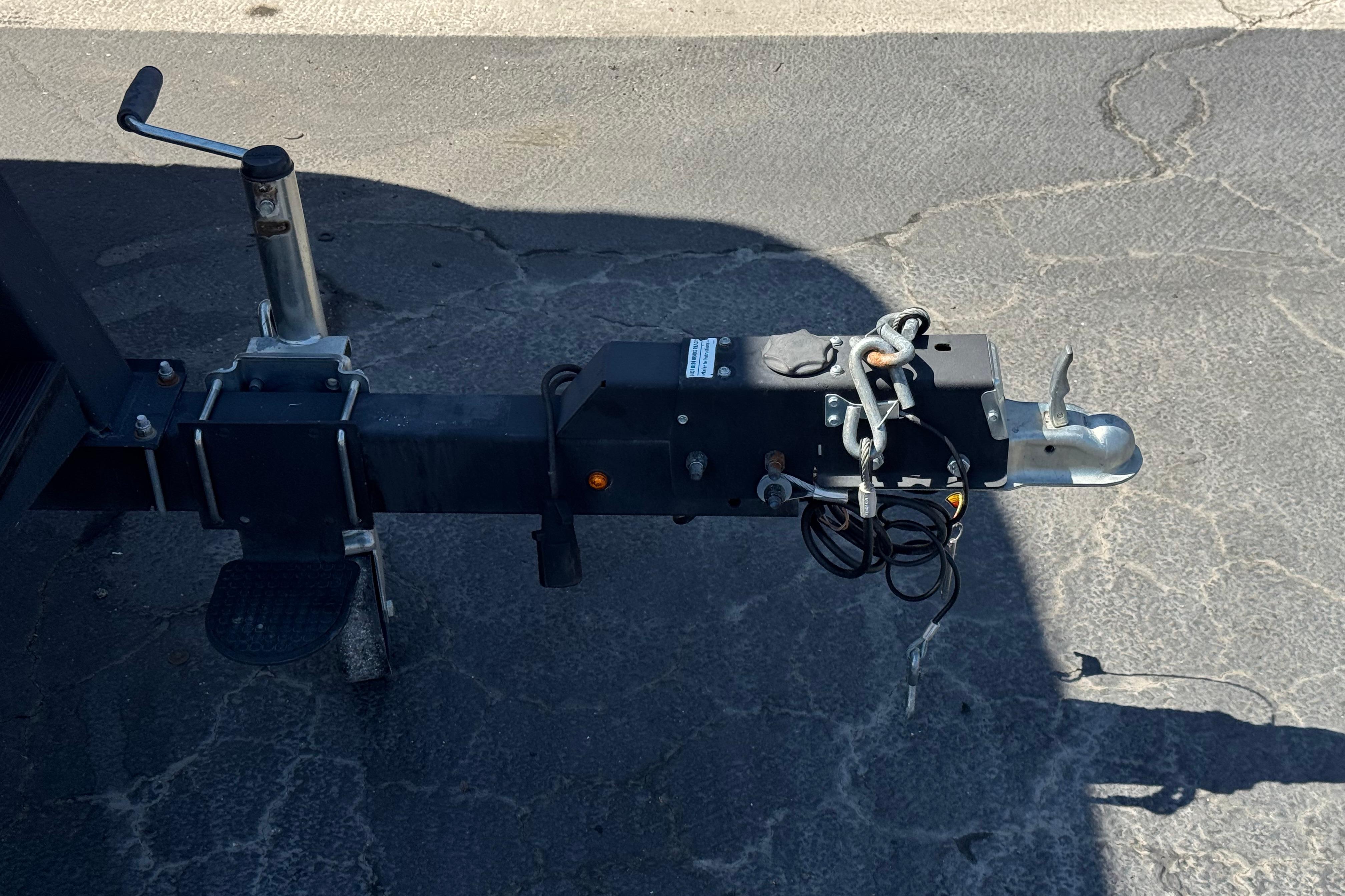 Trailer hitch of a 2018 Sun Tracker SportFish 22 DLX on asphalt pavement.