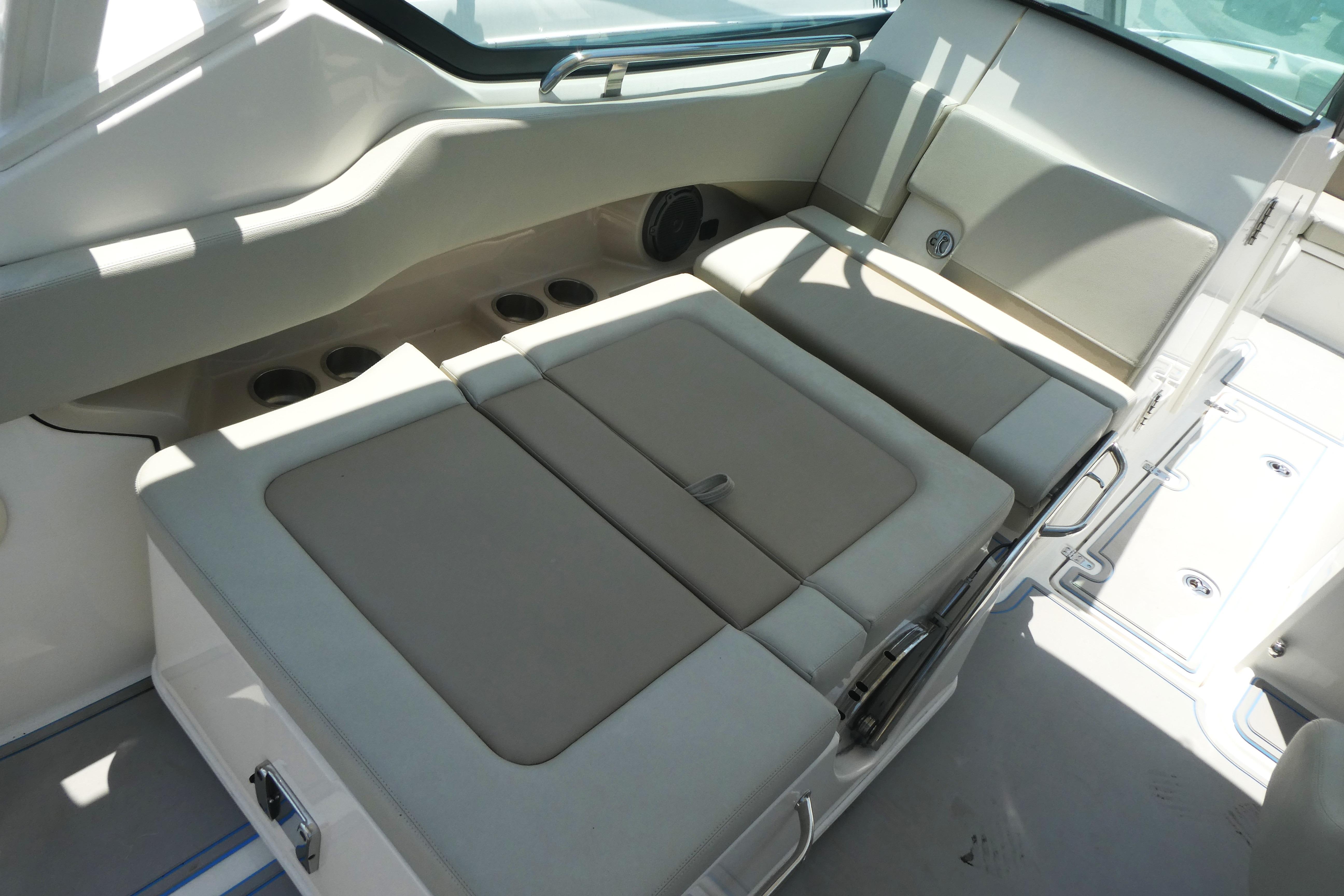 2022 Boston Whaler 240 Vantage interior seating area with beige cushions and cup holders.