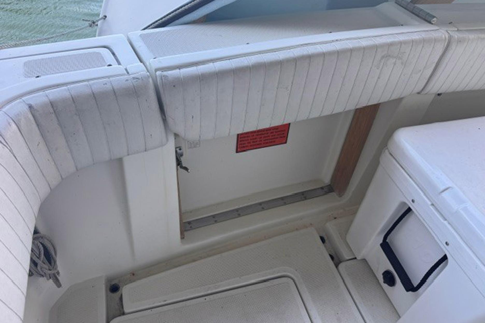 1988 Tiara Yachts 3300 Open interior with white cushioned seating and storage area.