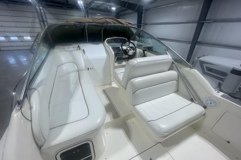 1998 Sea Ray 270 Sundancer boat interior with white seating and steering console.