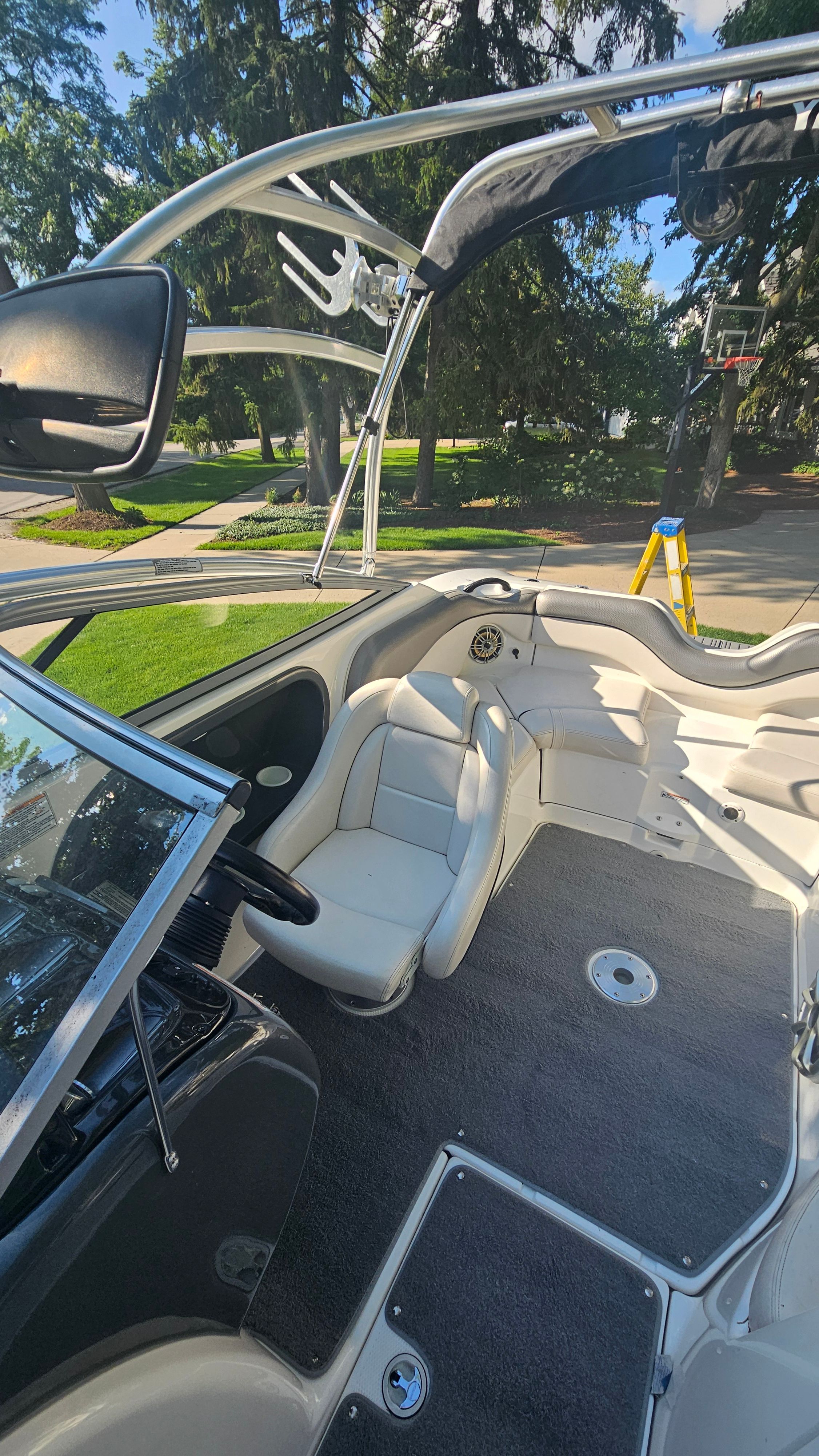 The image shows the cockpit of a 2010 Yamaha AR210 boat with white seats and gray carpet.