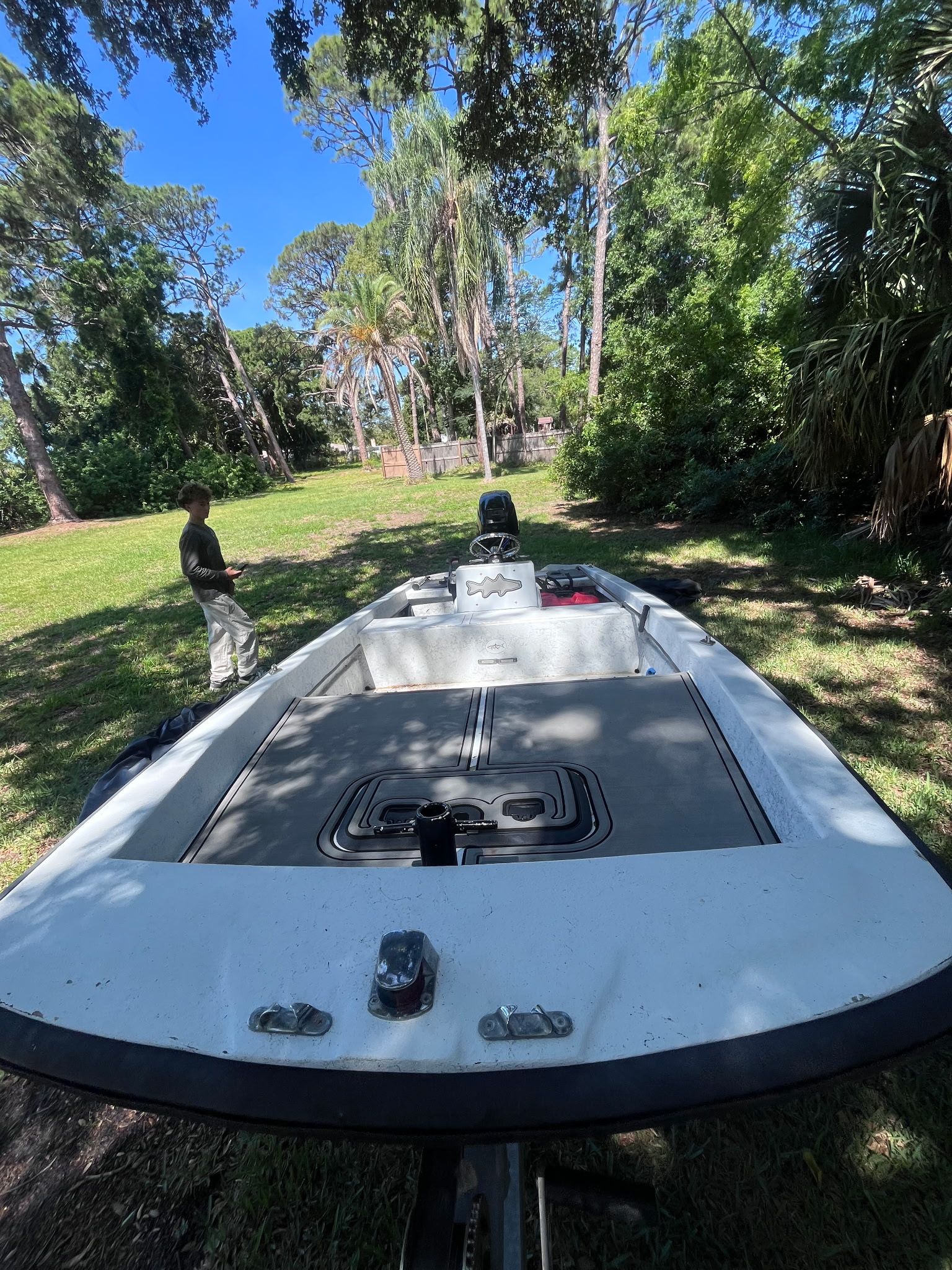 A 1974 McKee Craft Skiff is on a grassy area, surrounded by trees.