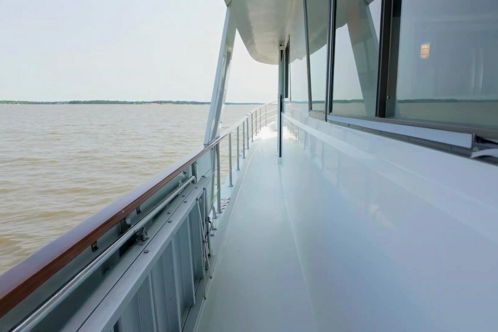 Side deck view of 1980 Hatteras 70 Motor Yacht on calm waters.
