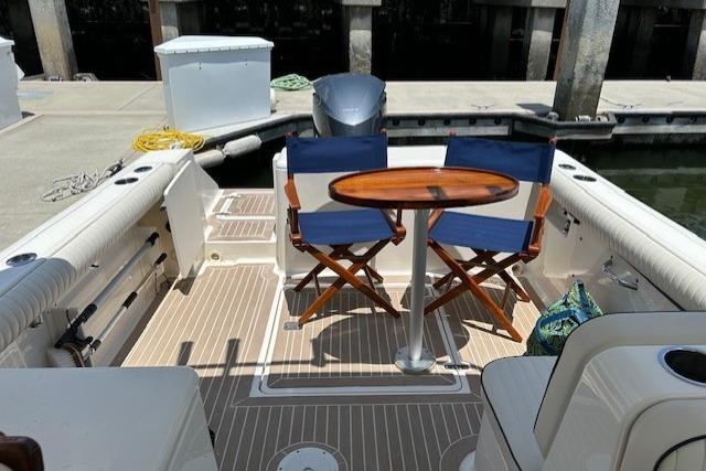 2013 Pursuit DC 265 Dual Console boat with seating and table at dock.