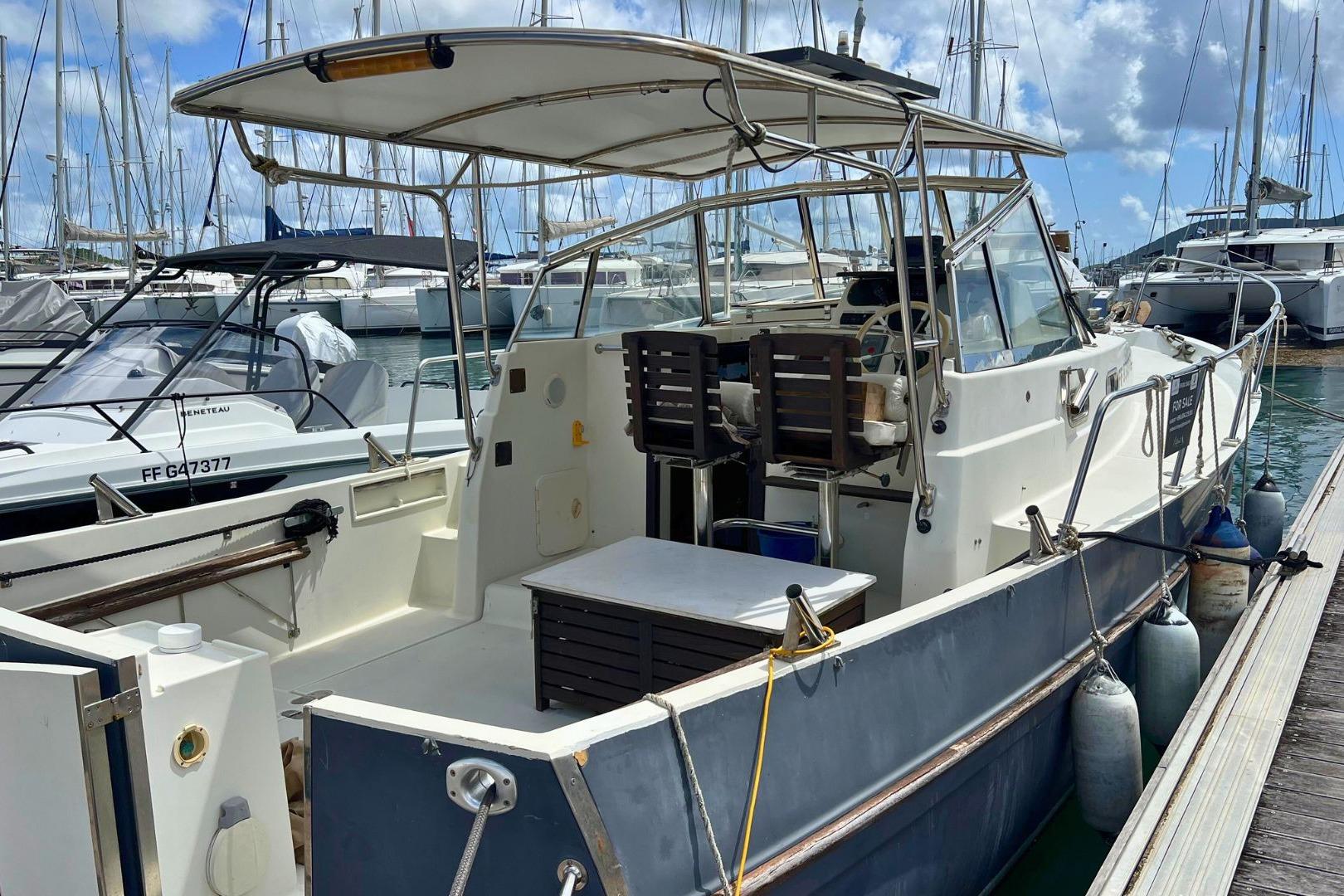 2006 Rhea 850 boat docked at marina, surrounded by other vessels.