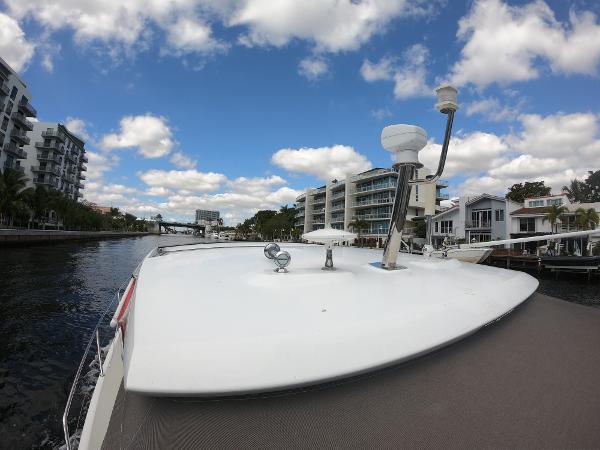 2017 Jeanneau NC 11 boat cruising along a scenic waterfront with modern buildings.