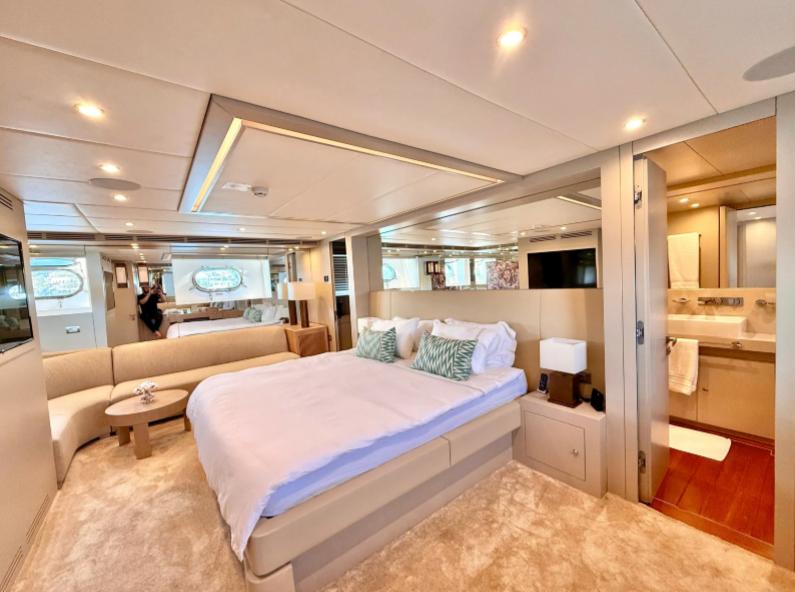 Luxurious bedroom interior of 2007 Riva 115 Athena yacht with modern decor and ensuite bathroom.