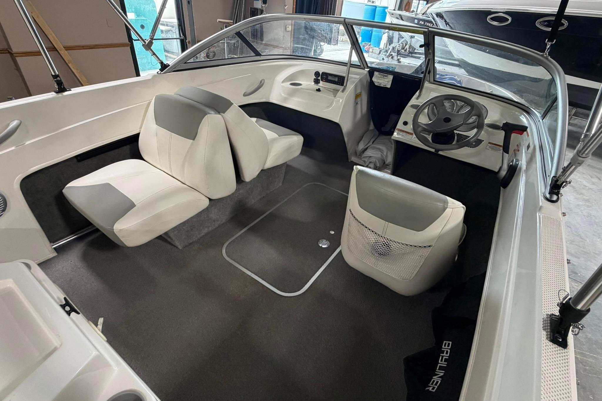 2012 Bayliner 175 Bowrider interior with gray and white seating, steering wheel, and dashboard.