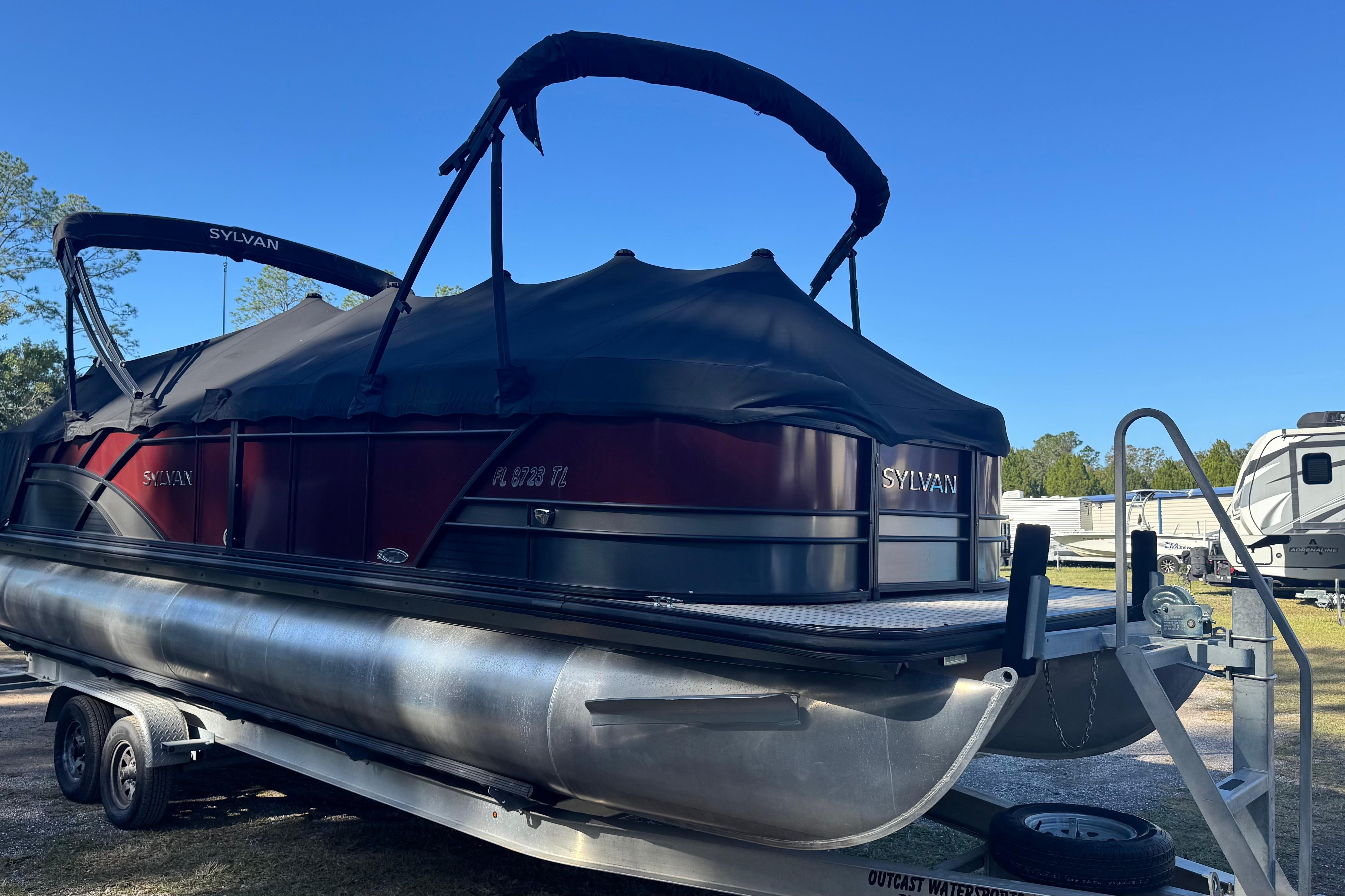 2023 Sylvan L5 CLZ pontoon boat on trailer, covered and parked outdoors.