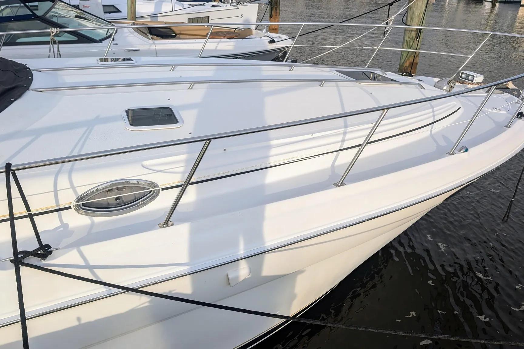 2000 Sea Ray 380 Sundancer yacht docked at marina, showcasing sleek white exterior.