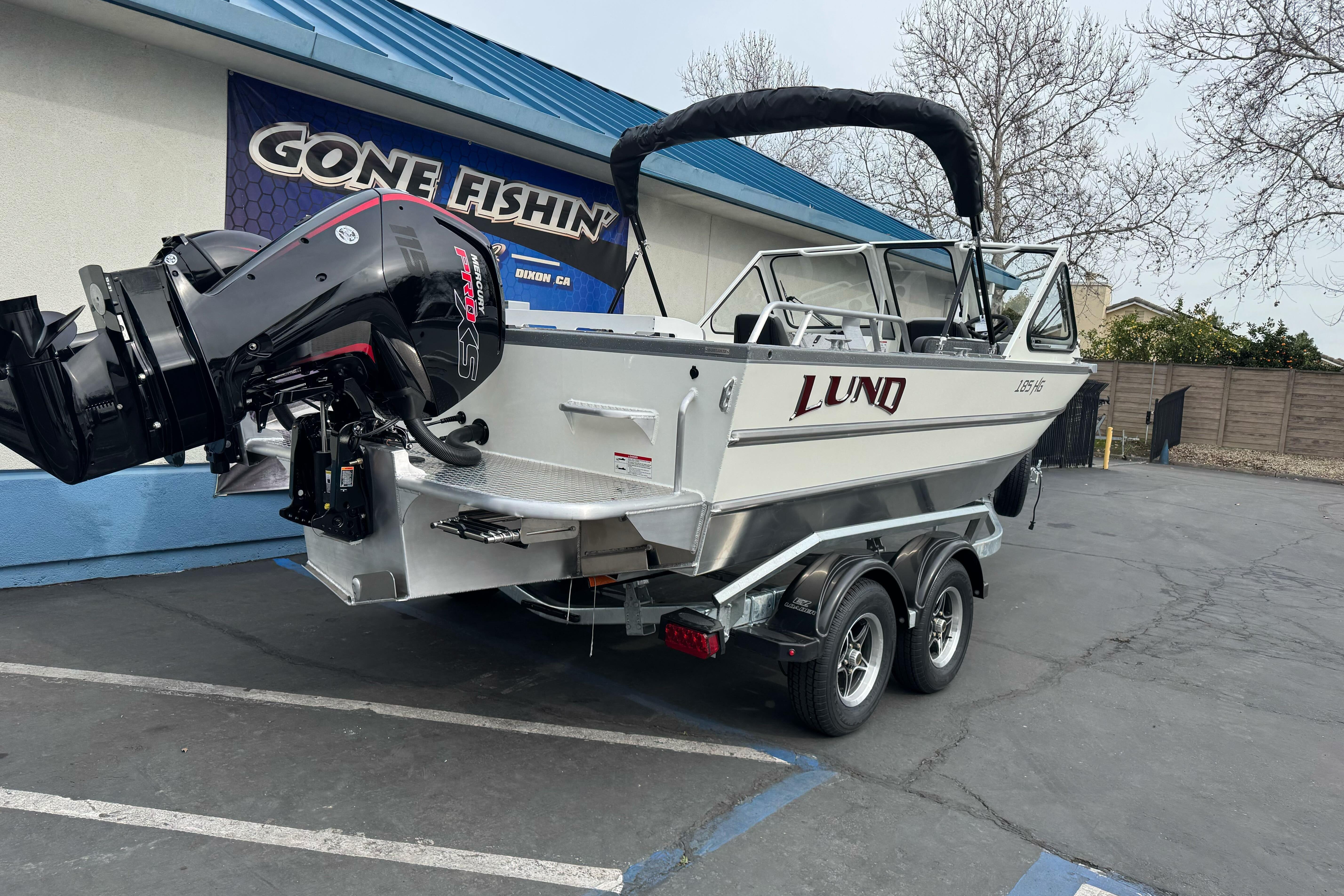 2026 Lund 185 Heavy Gauge boat on trailer, parked outside a fishing store.