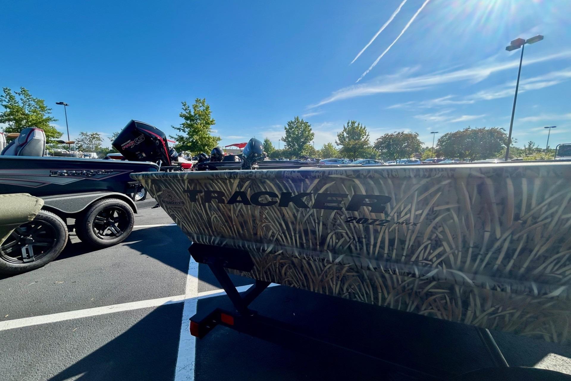 2026 Tracker Grizzly 2072 Utility boat with camouflage design in a parking lot.