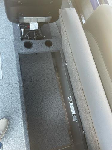 Interior of 2025 Spartan 240 Maximus Pro with storage compartment and cup holders.